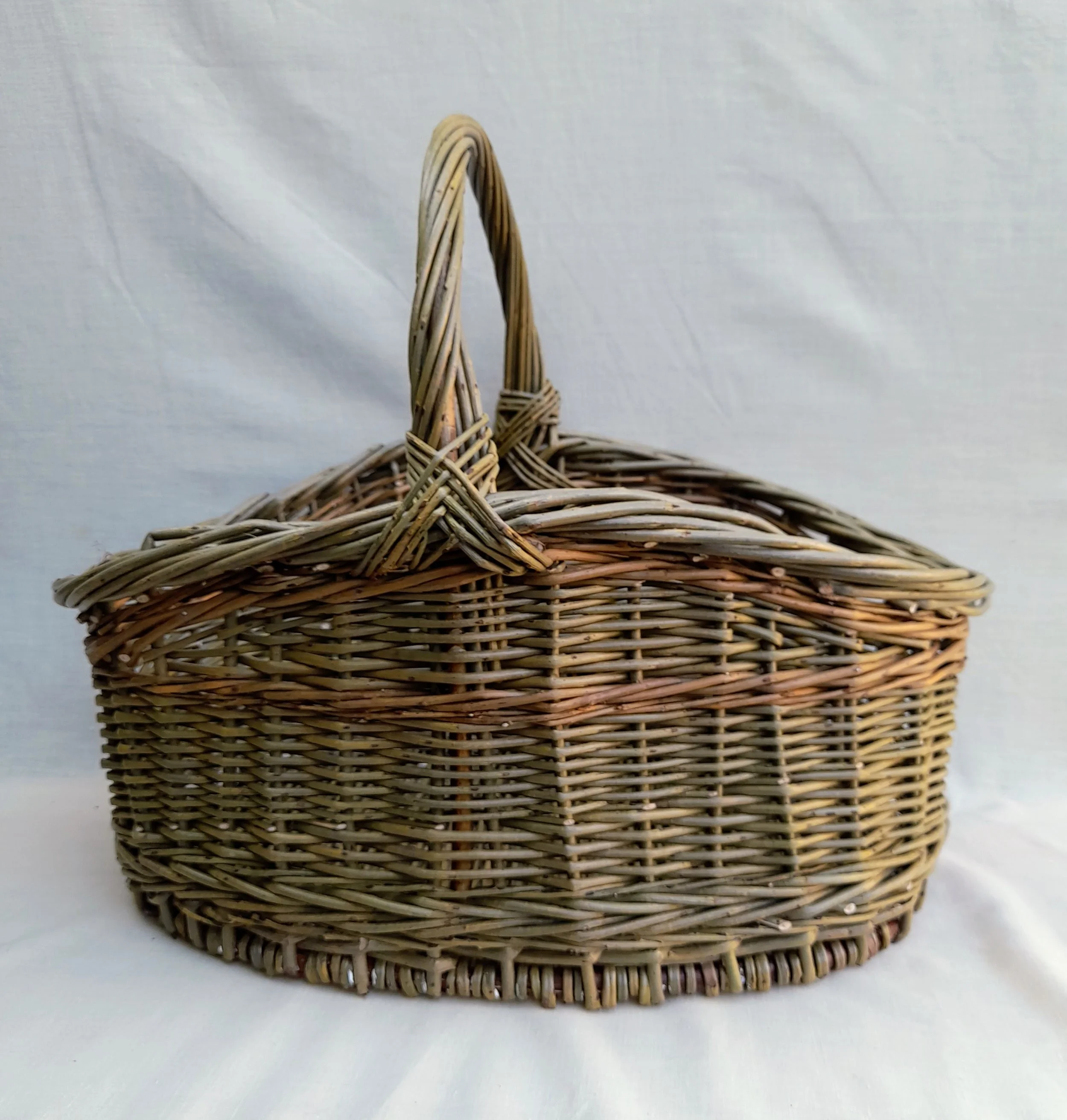 Wicker basket with handle against a white background.
