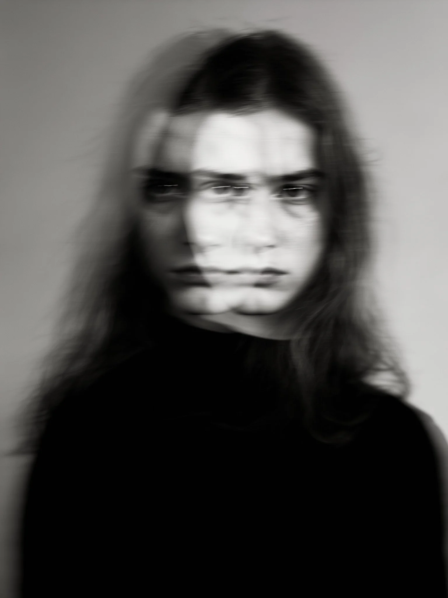 Black and white portrait of a woman with long hair, blurry effect.