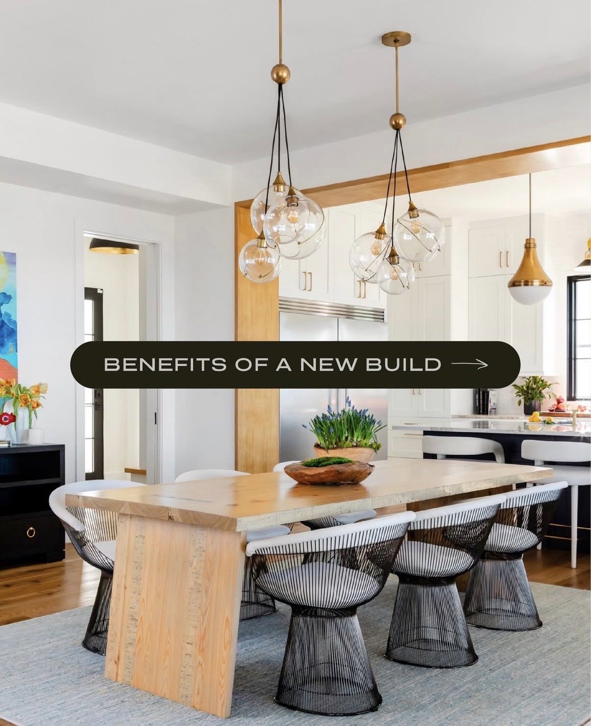 Modern dining room with a wooden table, black wire chairs, hanging glass pendant lights, and a sign that says 'Benefits of a New Build'.