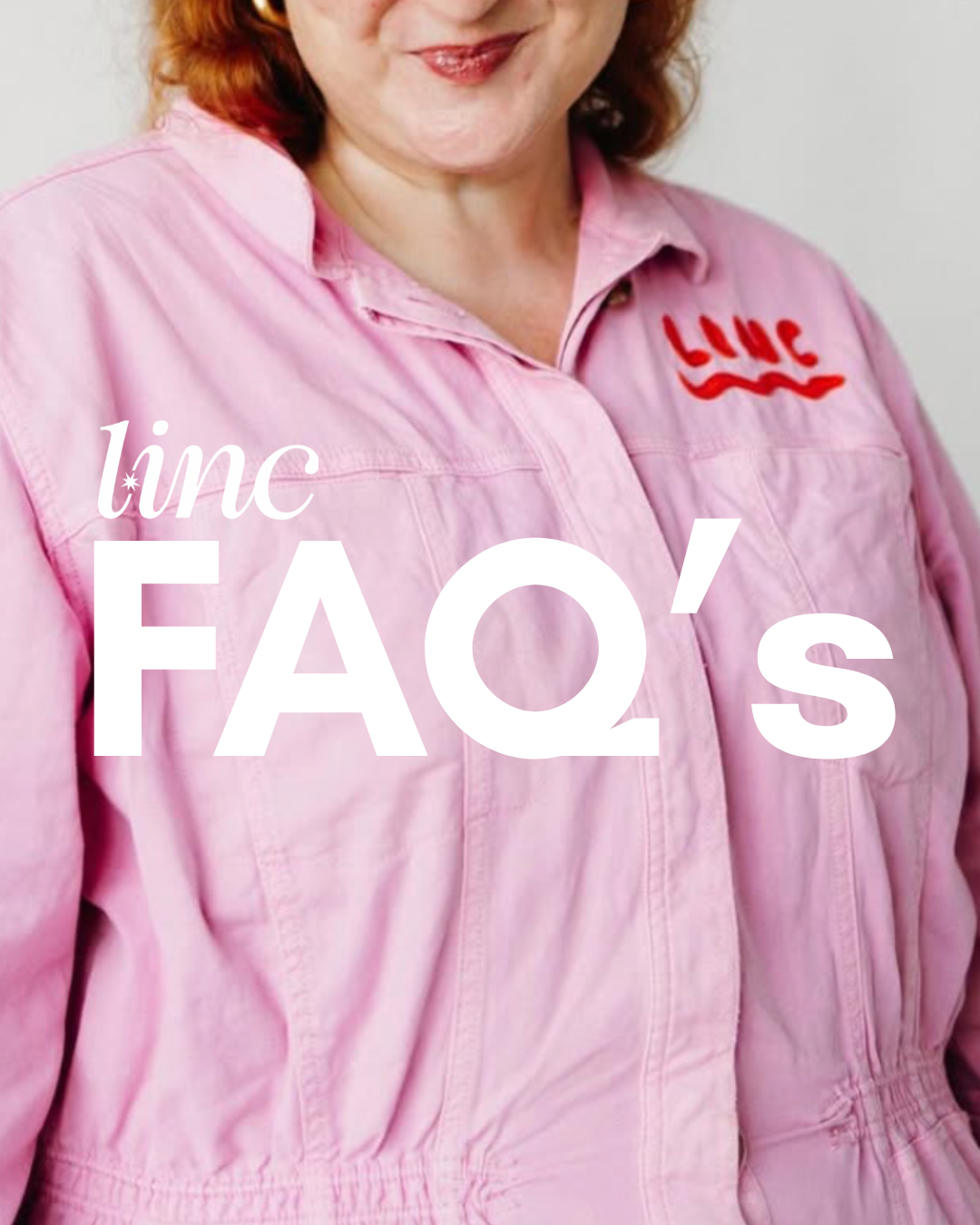 Close-up of a woman wearing a pink NASA flight suit with 'LIFE' embroidered on the chest, smiling slightly.