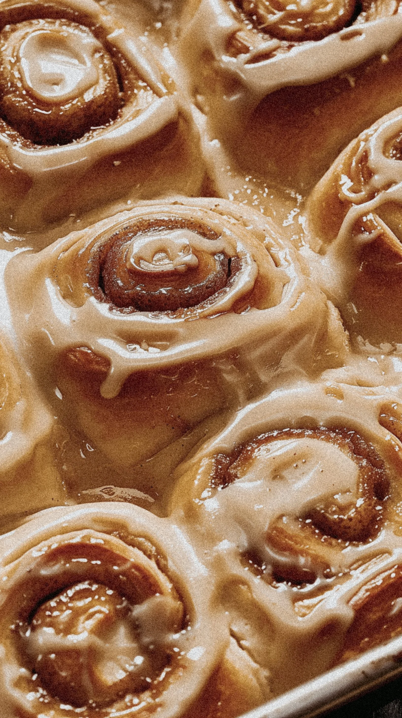 Close-up of cinnamon rolls topped with icing.