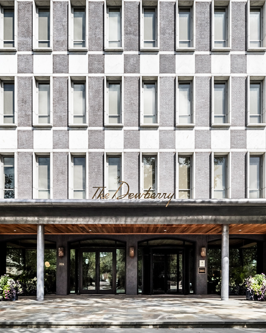 Front view of a modern hotel building with a sign that reads "The Duthbury" above the entrance.