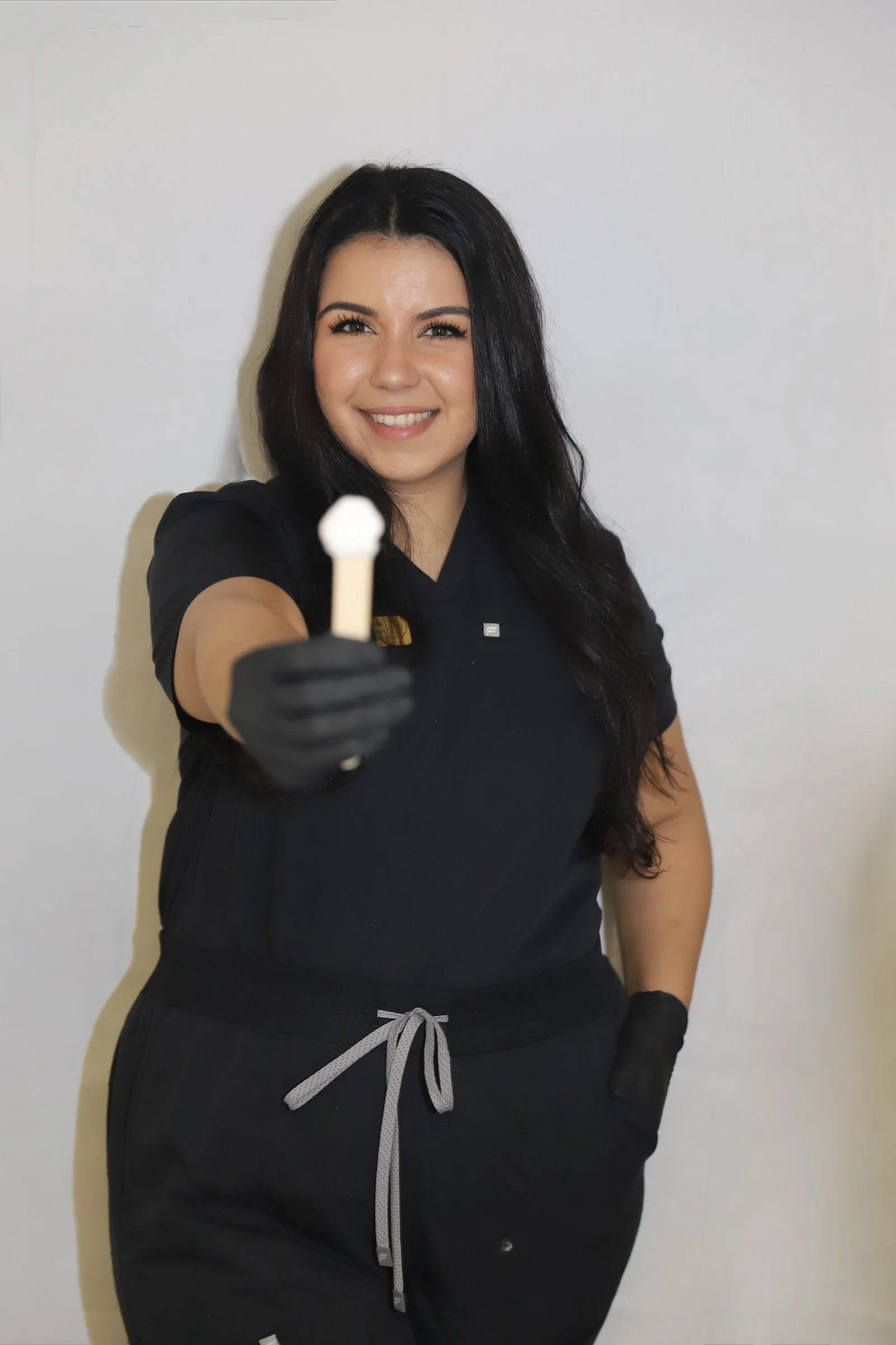 Licensed esthetician in San Dimas holding a wax stick while providing professional Brazilian waxing services