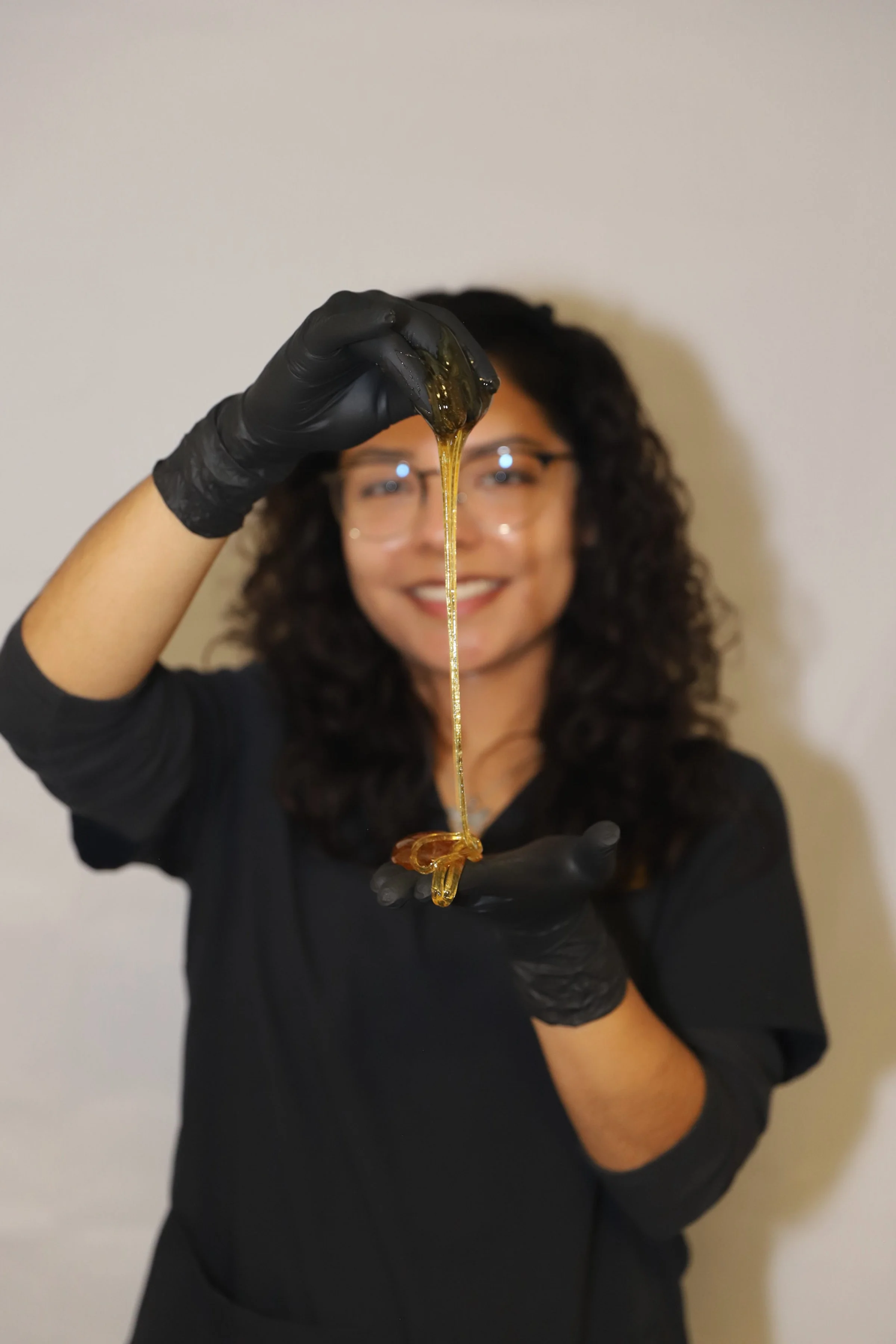 Professional sugaring esthetician in San Dimas holding natural sugar wax for smooth, irritation-free hair removal.