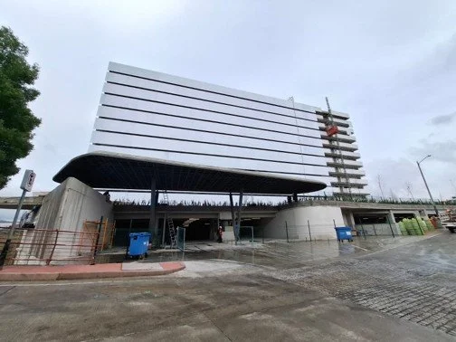 Edificio moderno en construcción, con grúa y andamios, en un día nublado