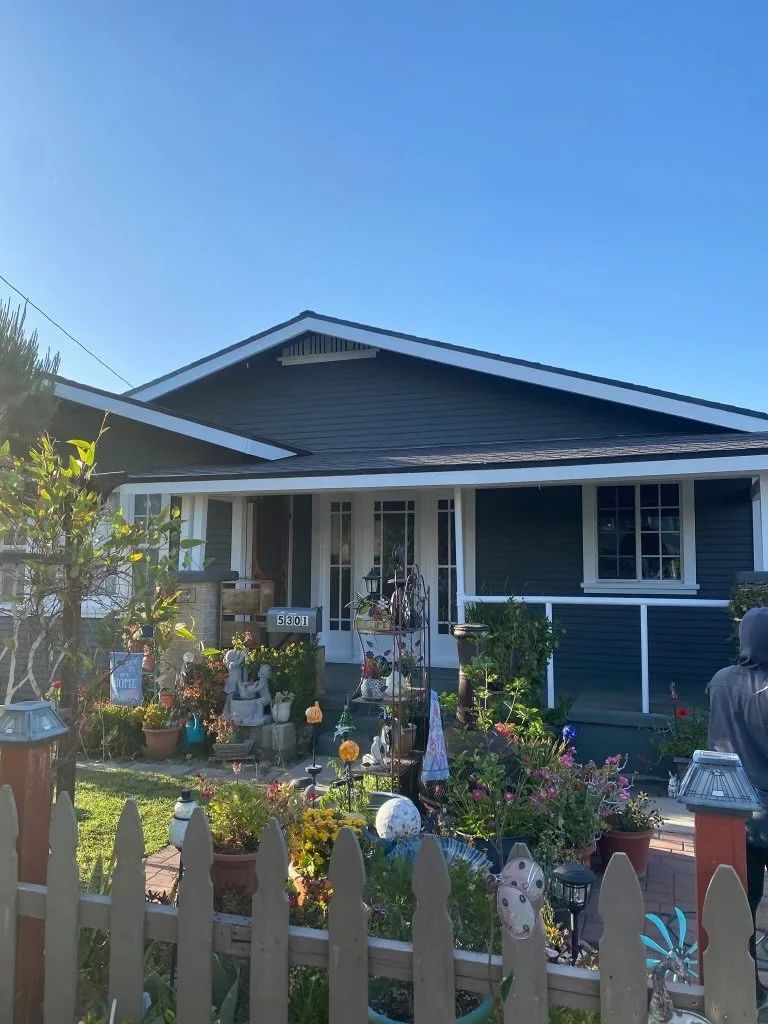 Front yard of a house decorated with garden ornaments and flowers.