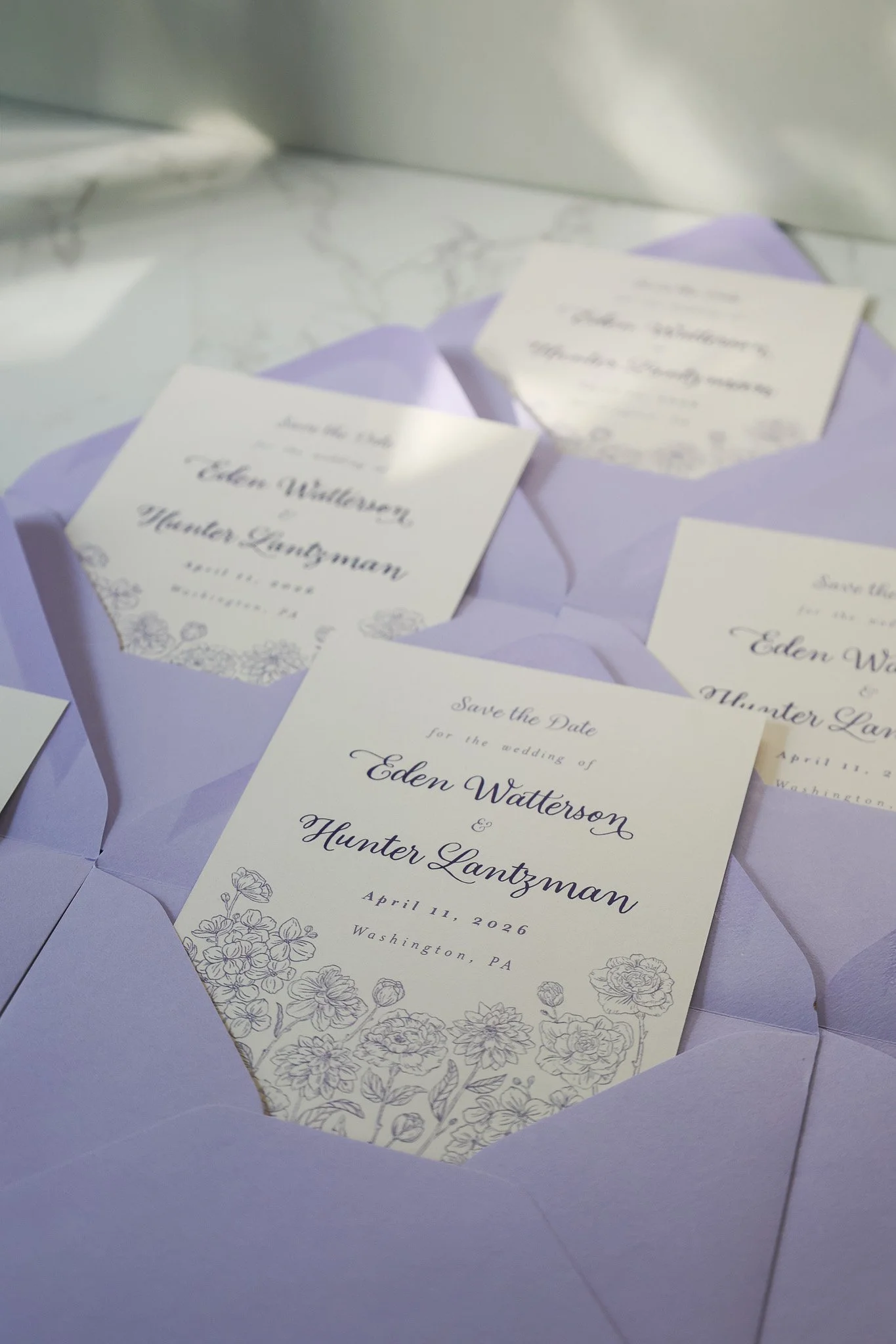 Wedding invitation card with purple envelopes and floral design, showing the names Eden Watterson and Hunter Lantzman, for April 11, 2026, in Washington, PA.
