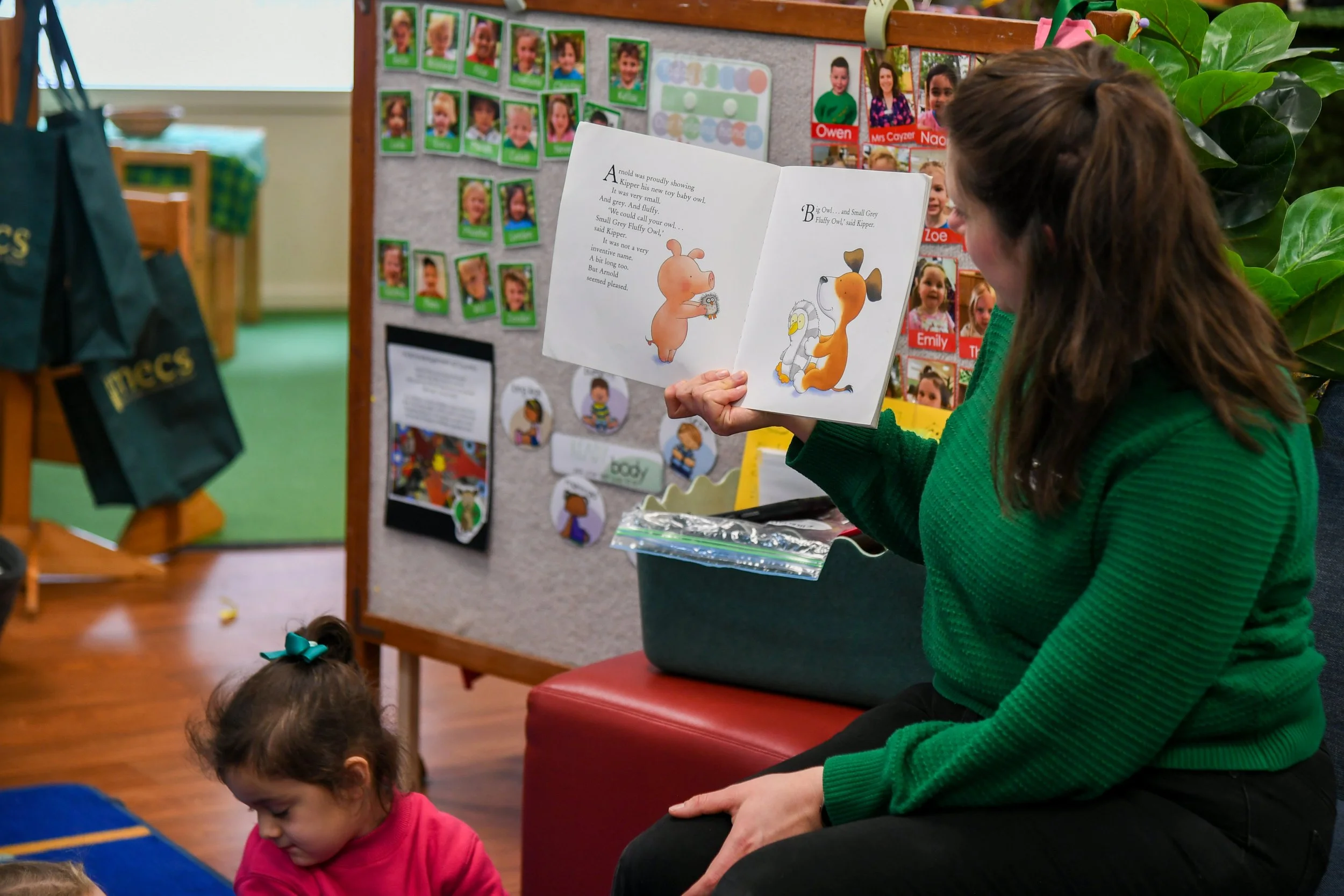 Kinder teacher reading book to classroom of students