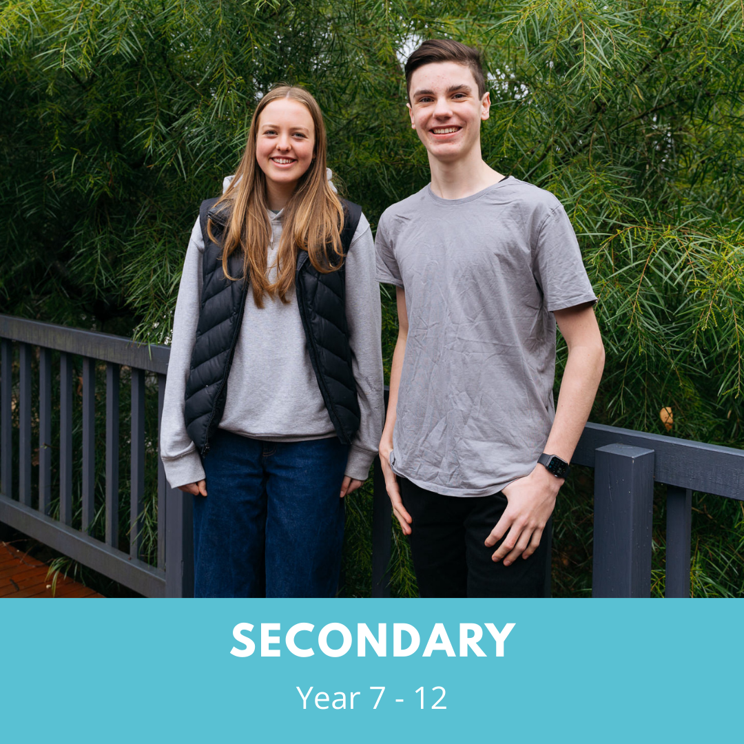 Two senior students, one female and one male are standing facing the camera and smiling. There is a light blue banner at the bottom of the image that reads Secondary - Year 7 to 12