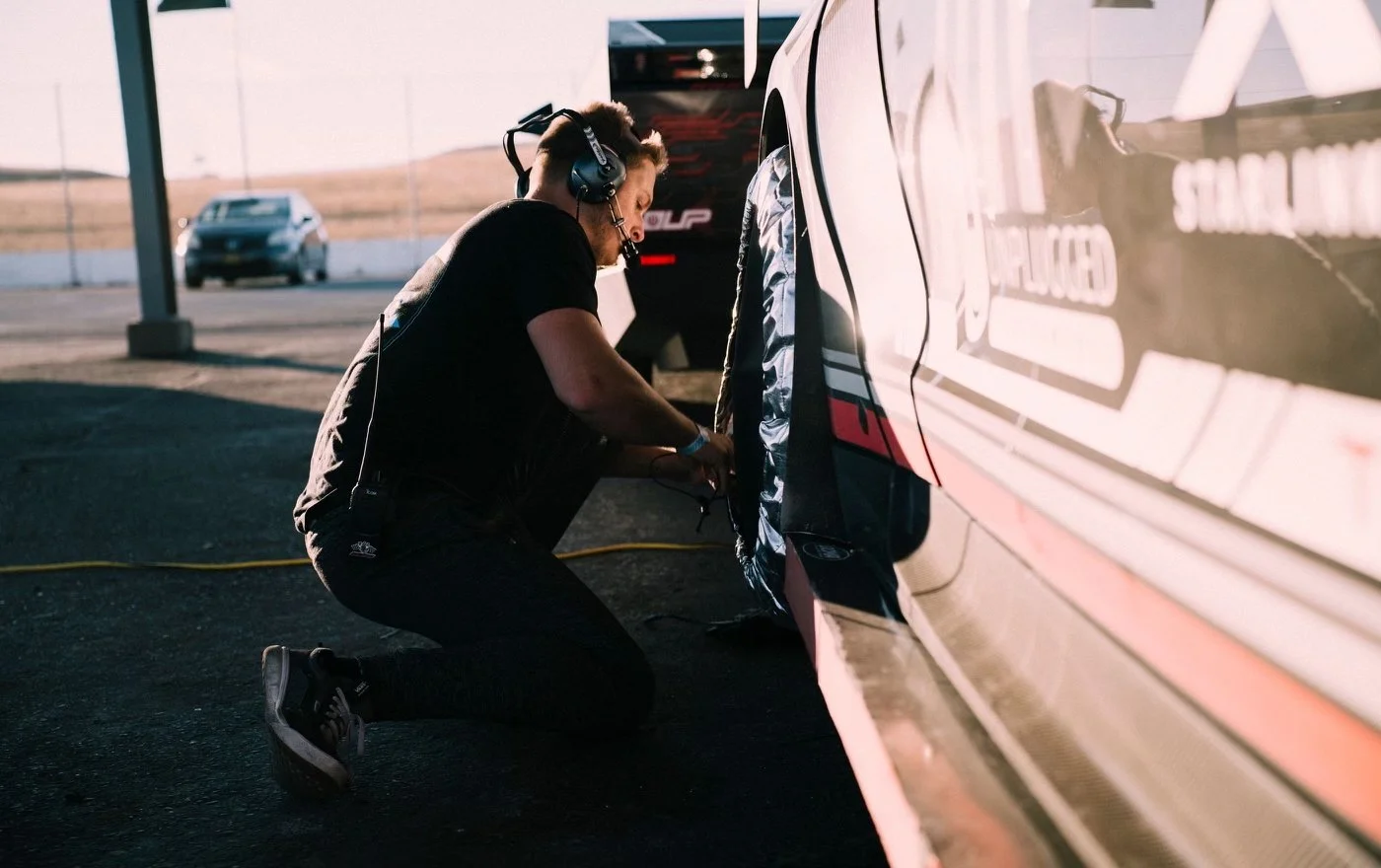 Our head coach, Maxwell Lisovsky, offering trackside support and lap coaching for a professional driver at Thunderhill Raceway during a Gridlife event.