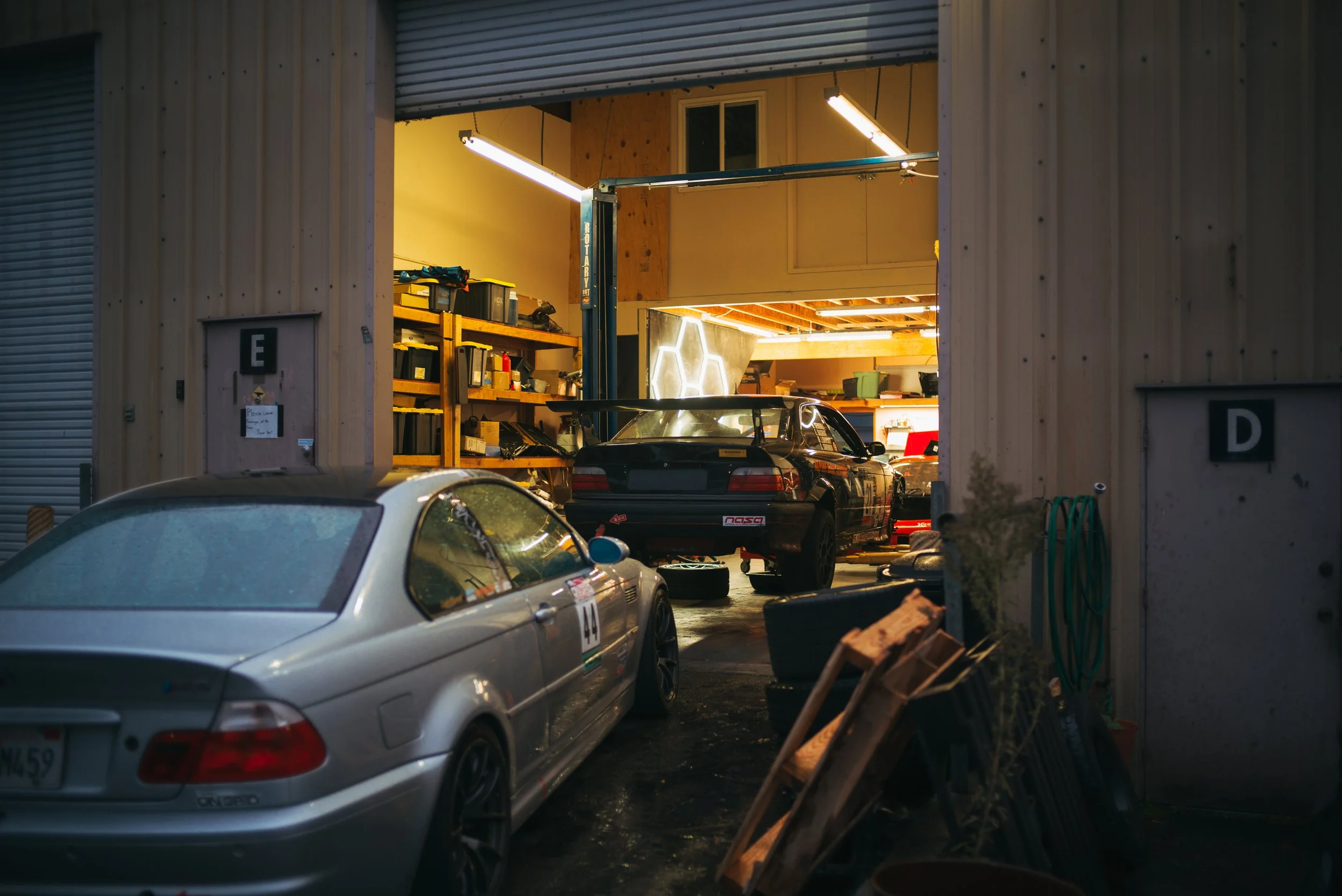 The Alpine Race Service shop, featuring a customer E46 M3 and a shop racing E36 M3.