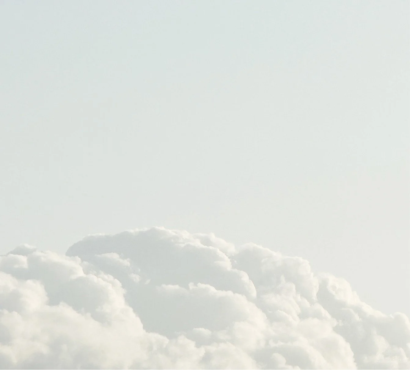 Cloudy sky with large, fluffy white clouds.