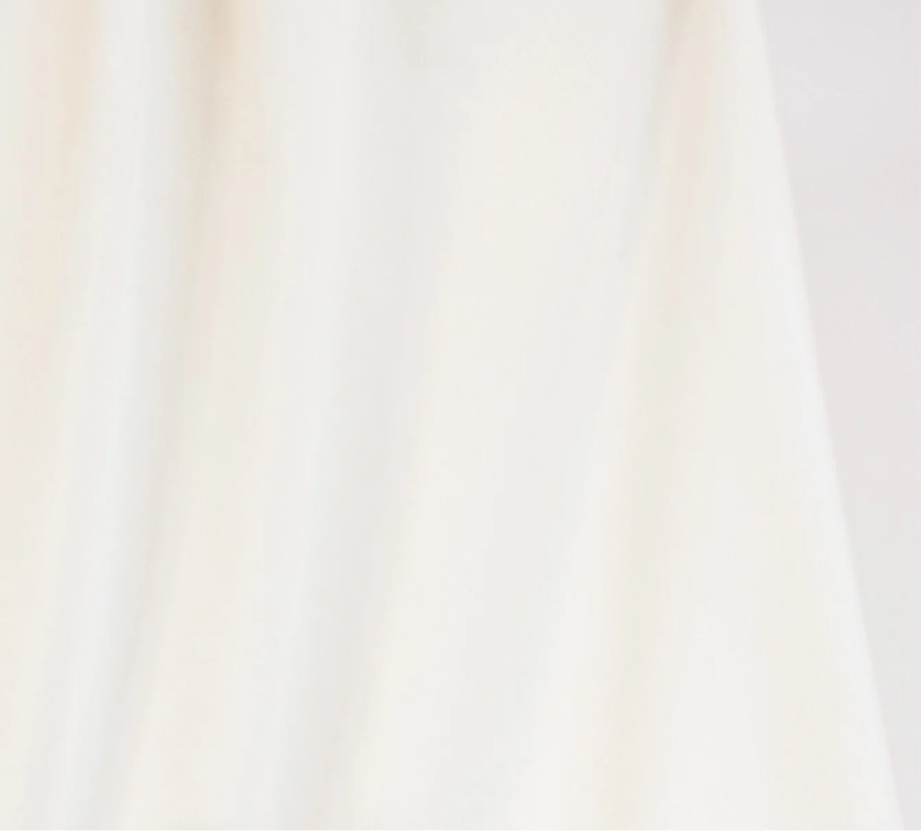 A plain, white fabric with subtle folds and texture.