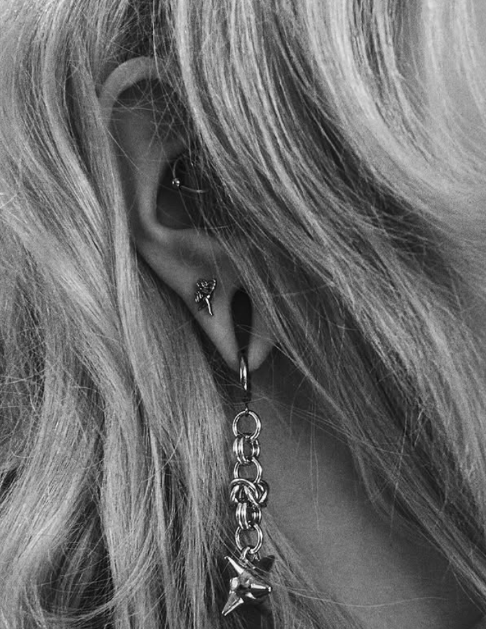 photo of an ear wearing silver chainmail earrings with a flail on the end