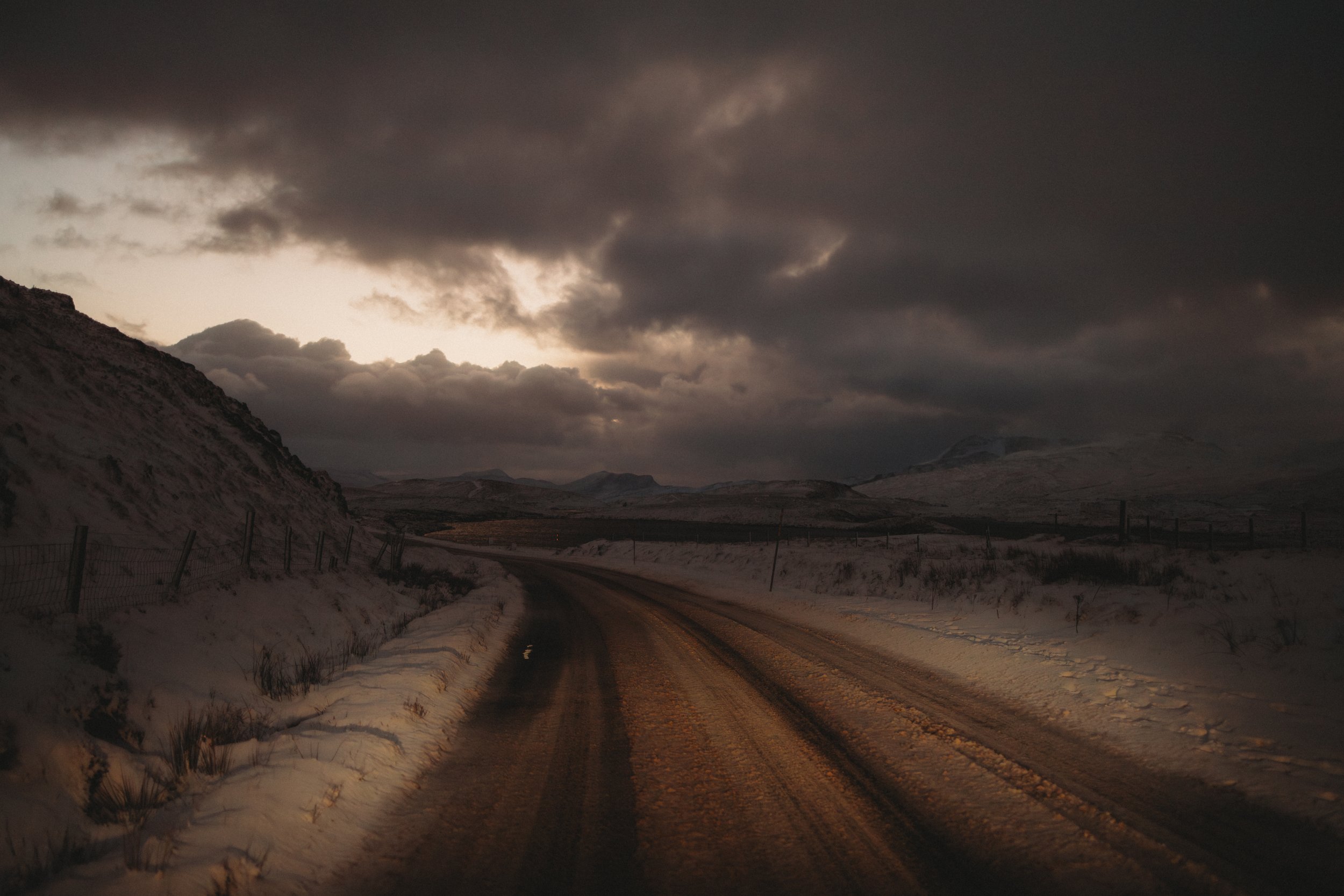 Driving towards Ullapool on a snowy road in late winter afternoon