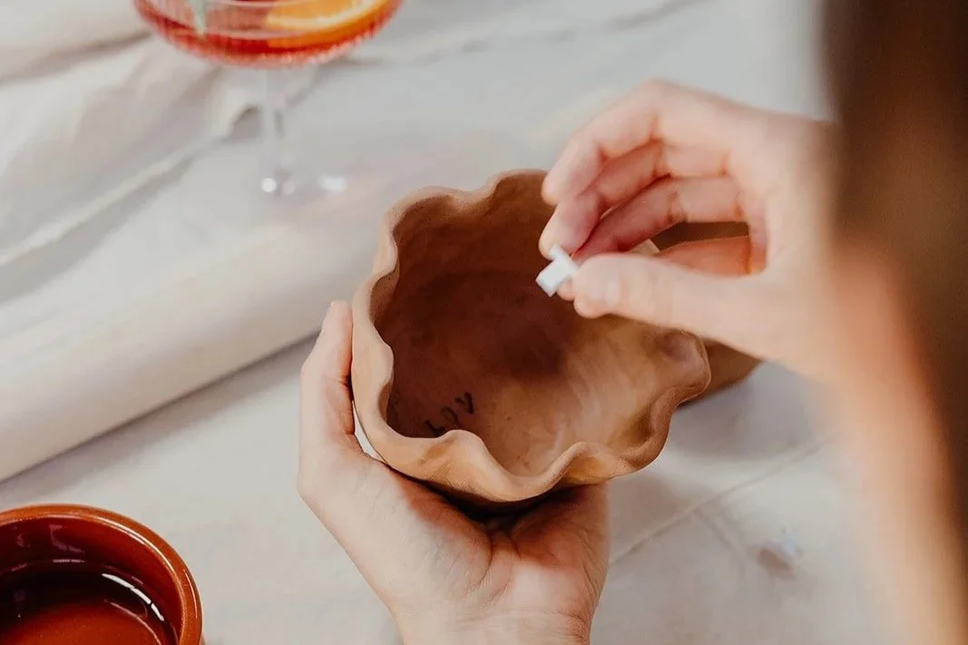 Holding a handmade wavy clay bowl at a handbuilding pottery class in Fremantle