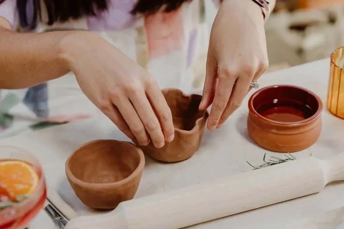 A workshop guest shaping a clay bowl by hand at a handbuilding pottery class in Fremantle