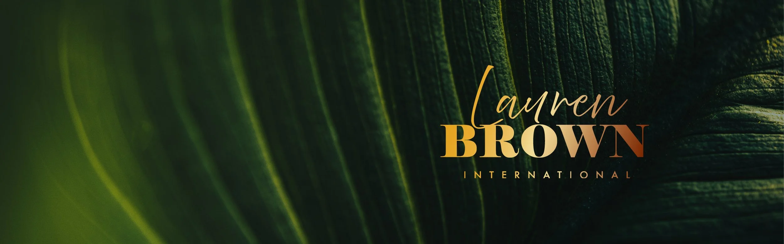 Logo for Lauren Brown International on a background of green palm leaves.