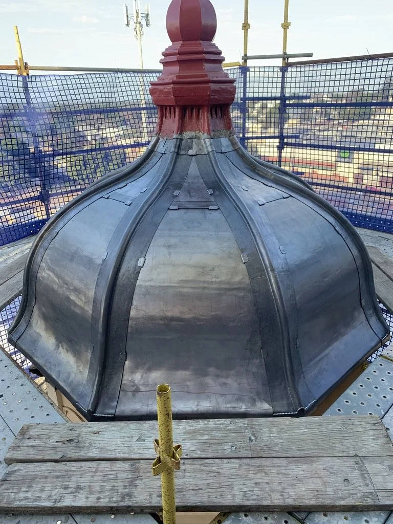 Curved bell shape lead roof with curved lead hips. 