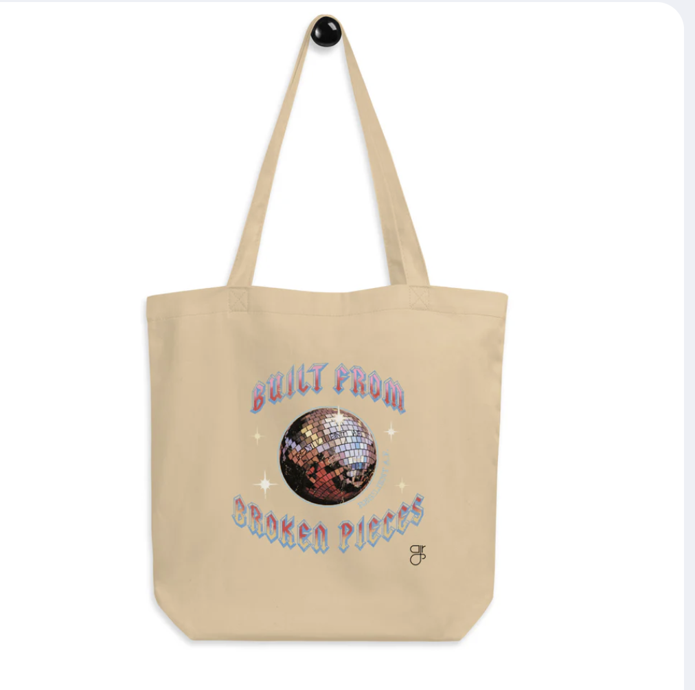 A photo of a canvas tote that says "Built From Broken Piece" with Disco Ball. 