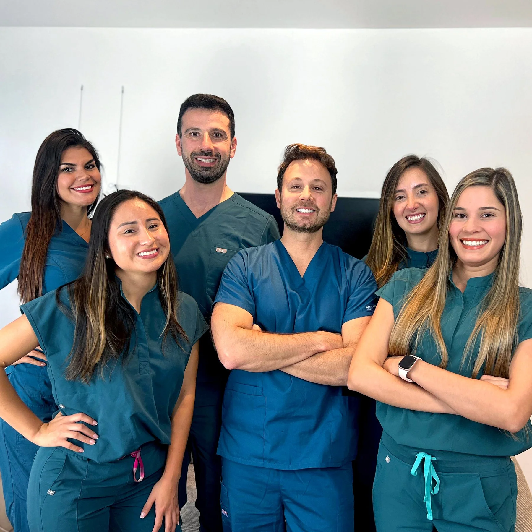 Grupo de profesionales de la salud vistiendo uniformes médicos en un entorno clínico.