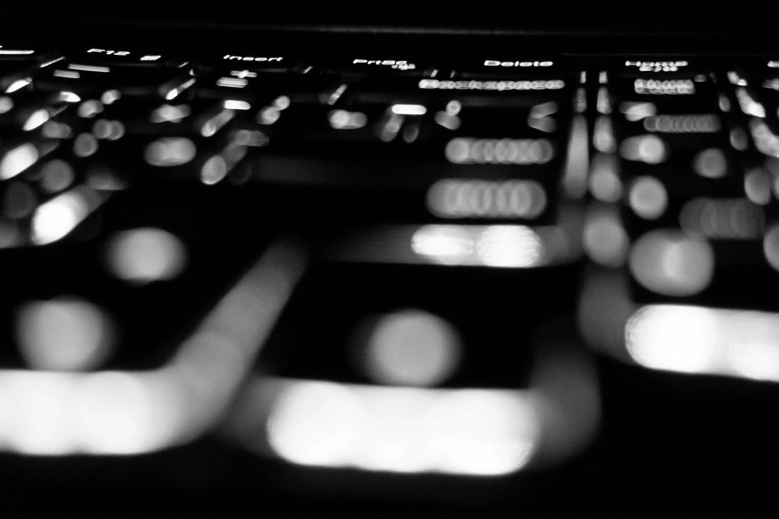 Nahaufnahme einer Computertastatur in Schwarz-Weiß, Fokus auf die Tasten. Dauerstress, Hyperviglianz, innere Unruhe, zu viel digital, offline sein.