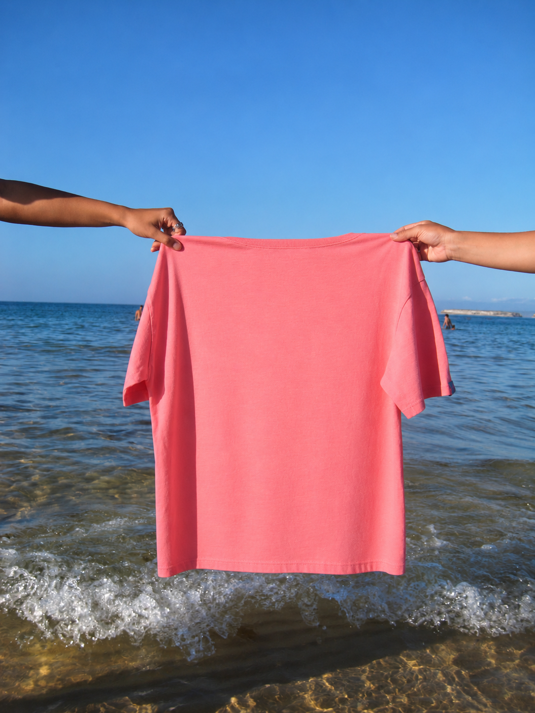 T-shirt rosa liso junto ao mar.png