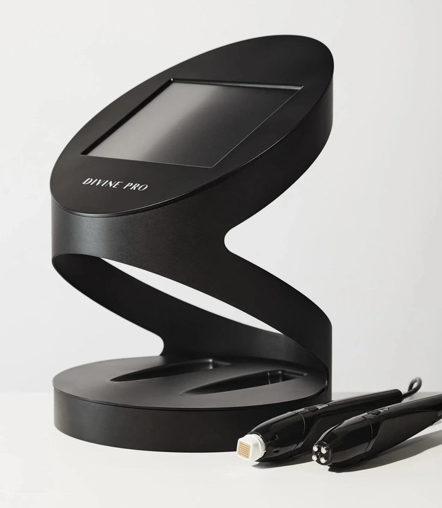 A black handheld ultrasound device labeled "Divine Pro" is shown alongside two pen-shaped ultrasound probes. The device has a rectangular screen and is set against a plain light background.