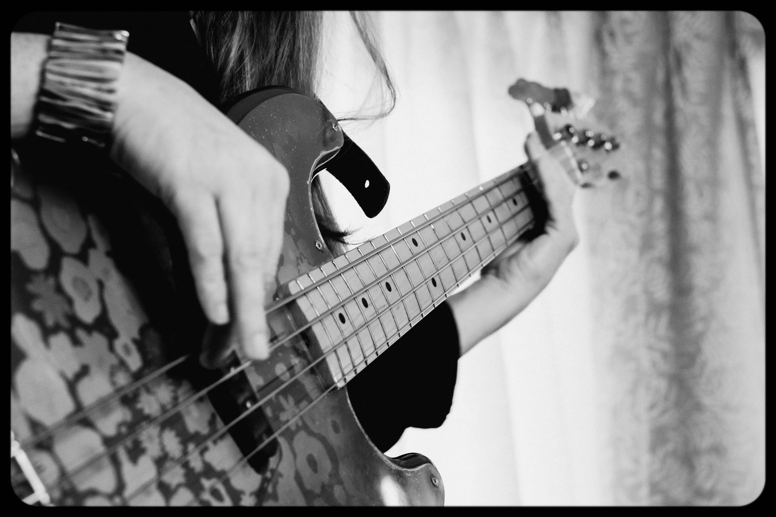 Person playing an electric bass guitar.