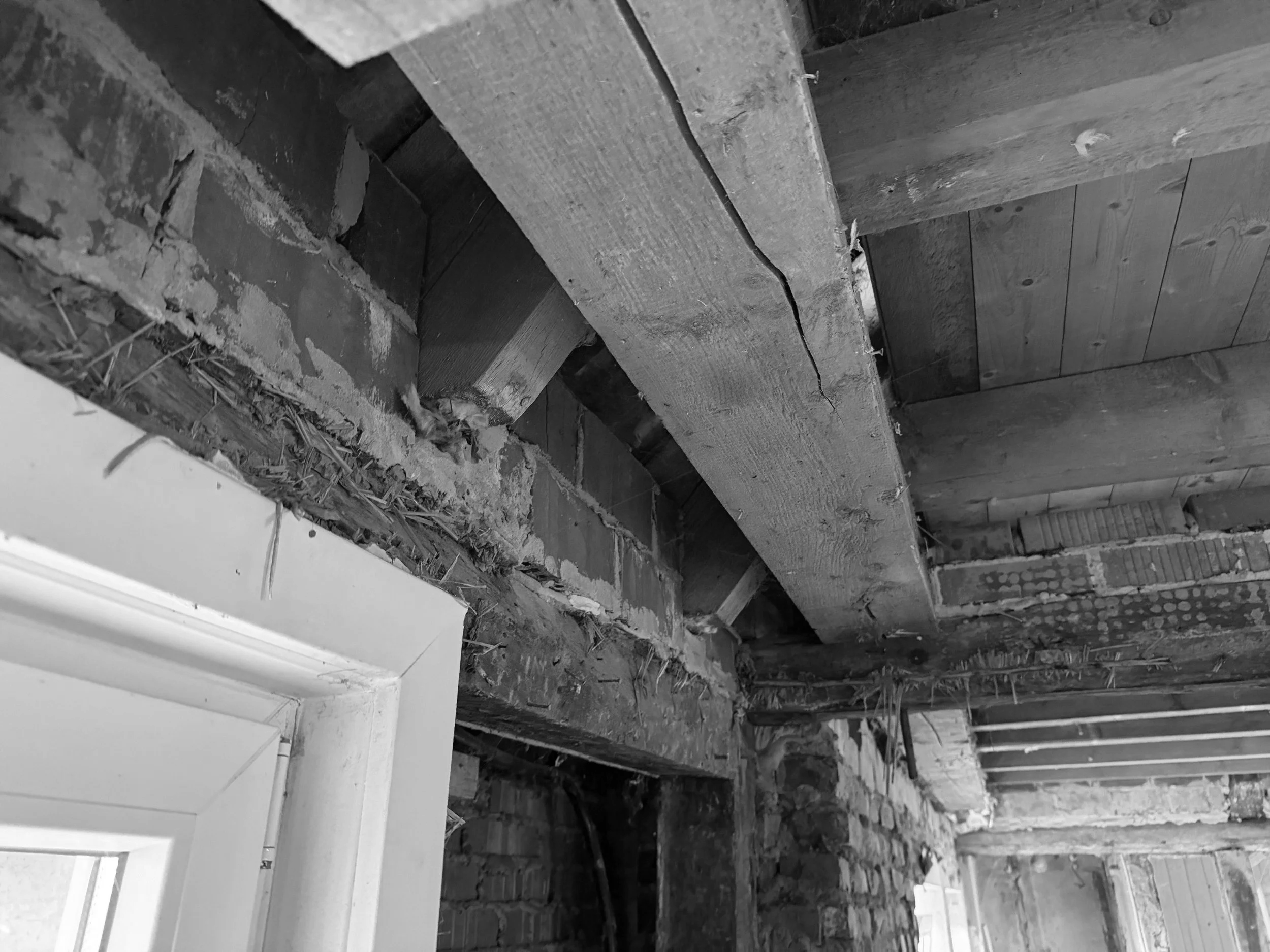 Bauarbeiten an Decke mit Holzbalken und Ziegelwänden in einem alten Gebäude