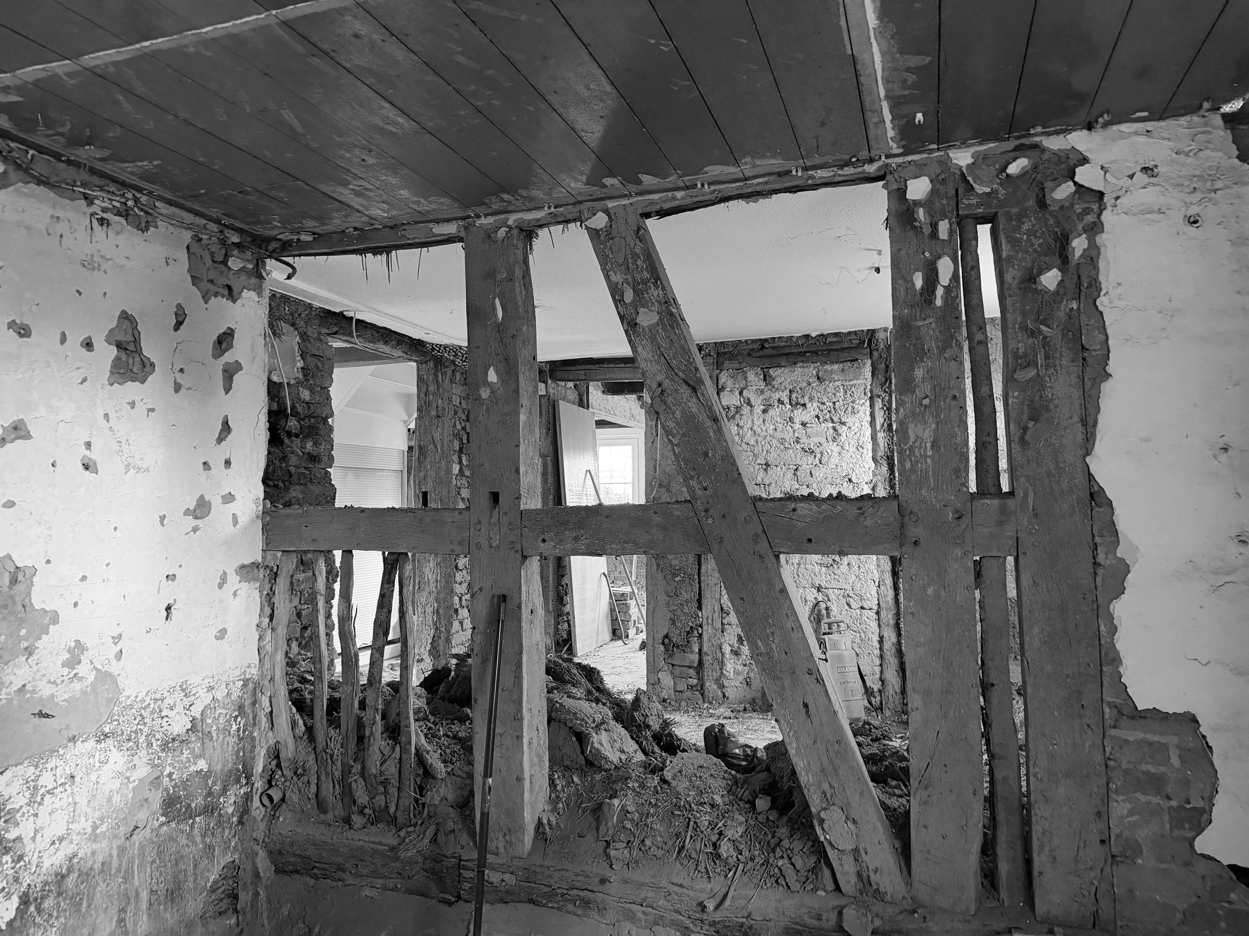 Baustelle mit Holzkonstruktion und alten Wänden, Innenraum bei Renovierungsarbeiten.