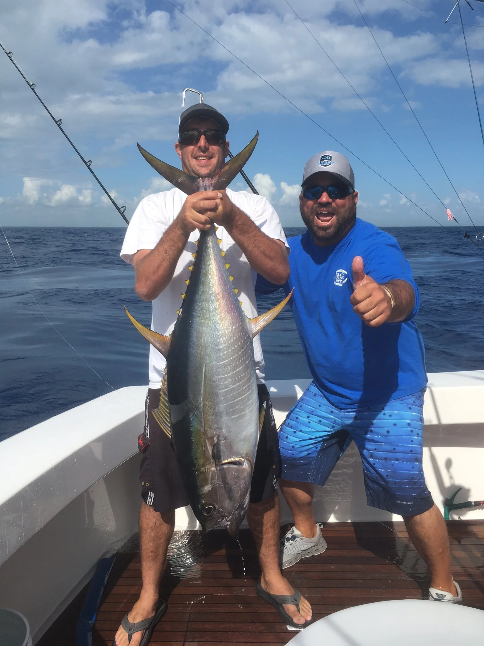 Two fishing mates show off a yellowfin tuna caught off the coast of South Florida.