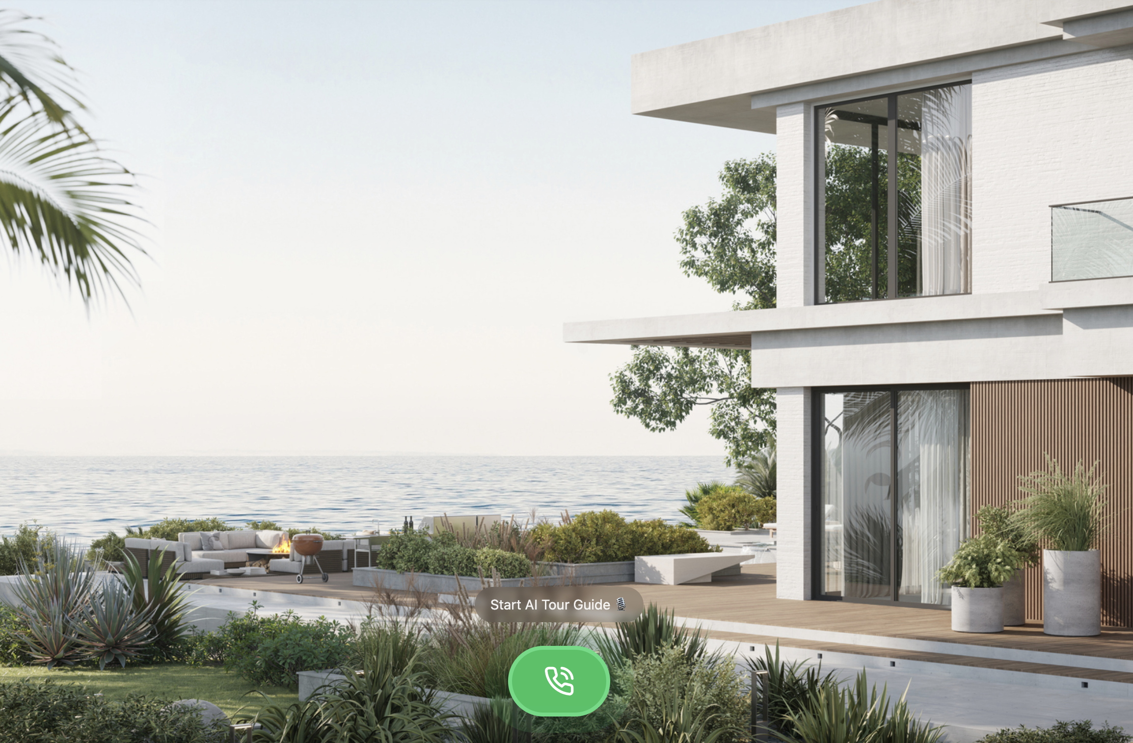 Modern beachfront house with large windows and spacious balcony, surrounded by lush greenery and outdoor seating area with a fire pit by the ocean.