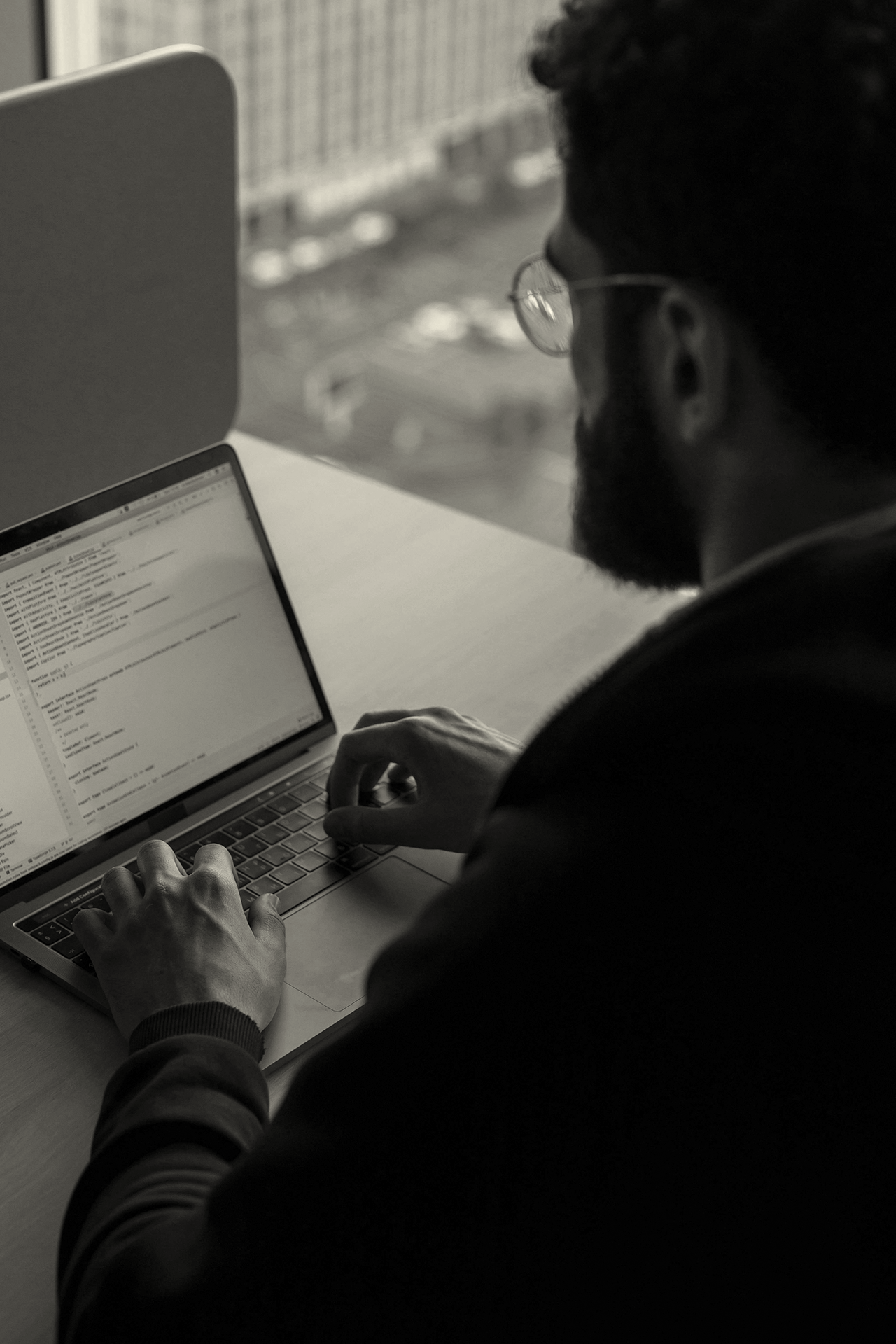 Developer coding on a laptop, representing investments in IT and technology