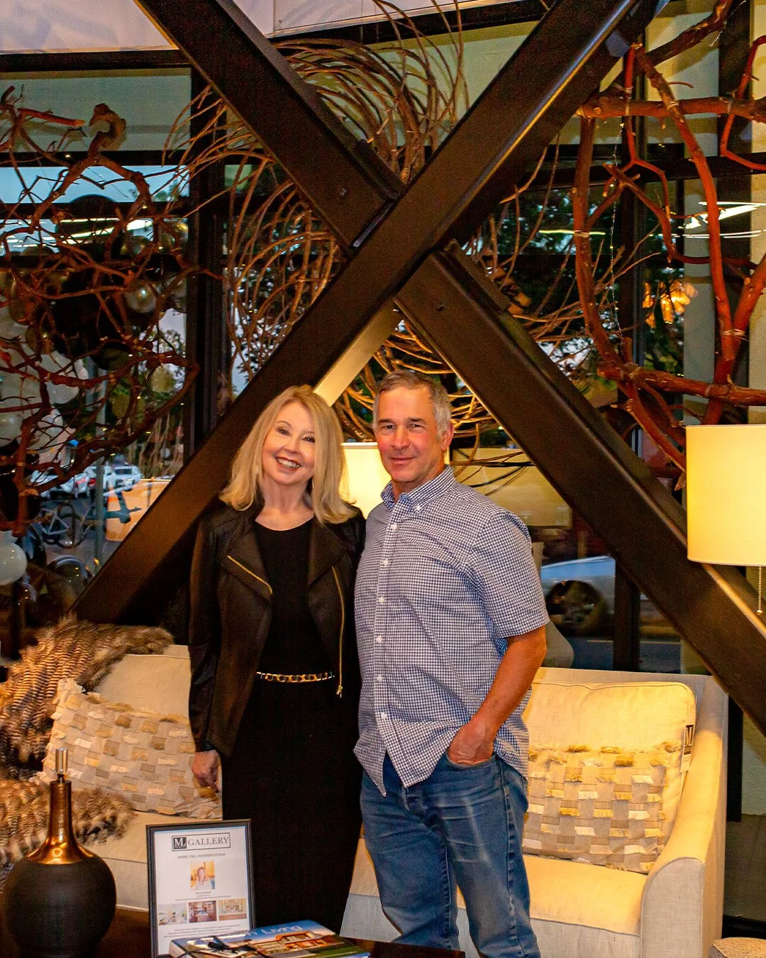 Marie and local artisan standing in front of  stick sculpture