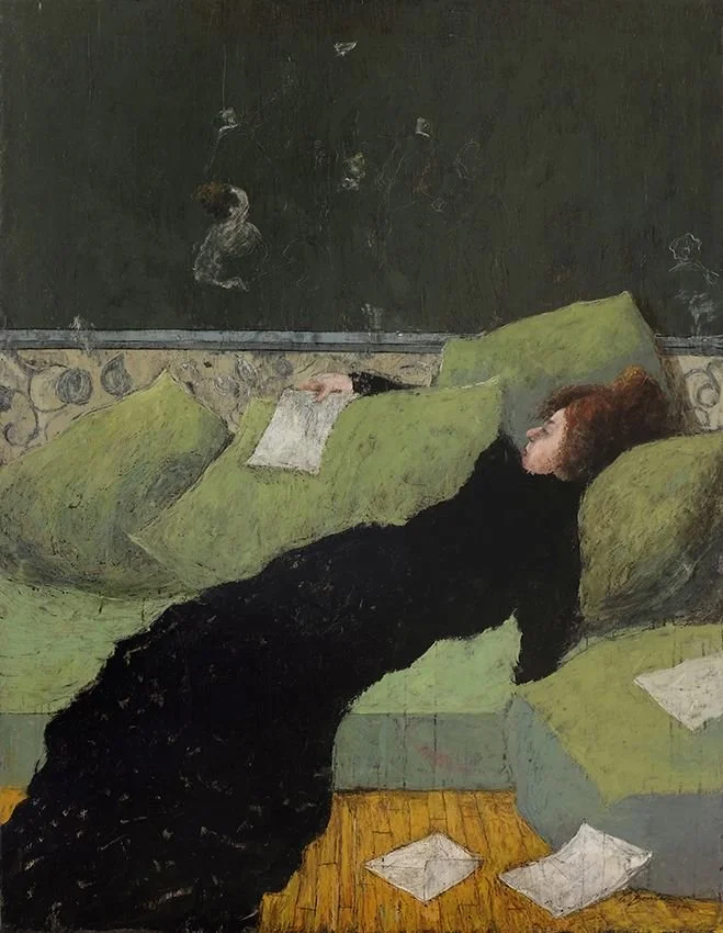 A woman with red hair lying on a green couch, reading a paper in a dimly lit room with scattered papers on the floor, a dark wall with drawings or stickers behind her.