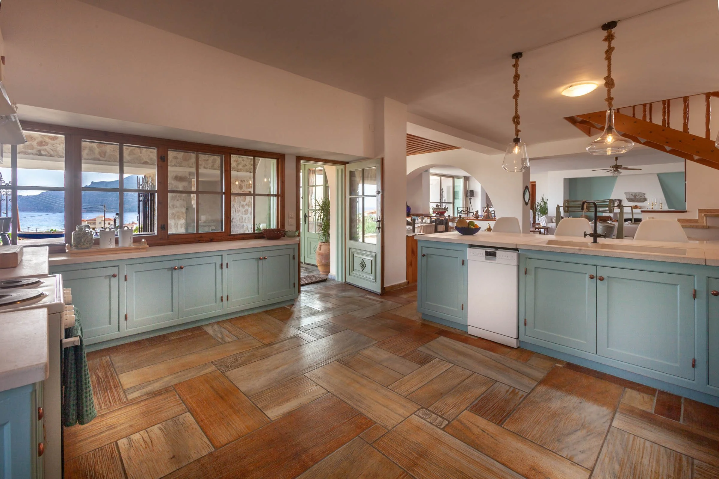 A blue and white kitchen over looking the sea.