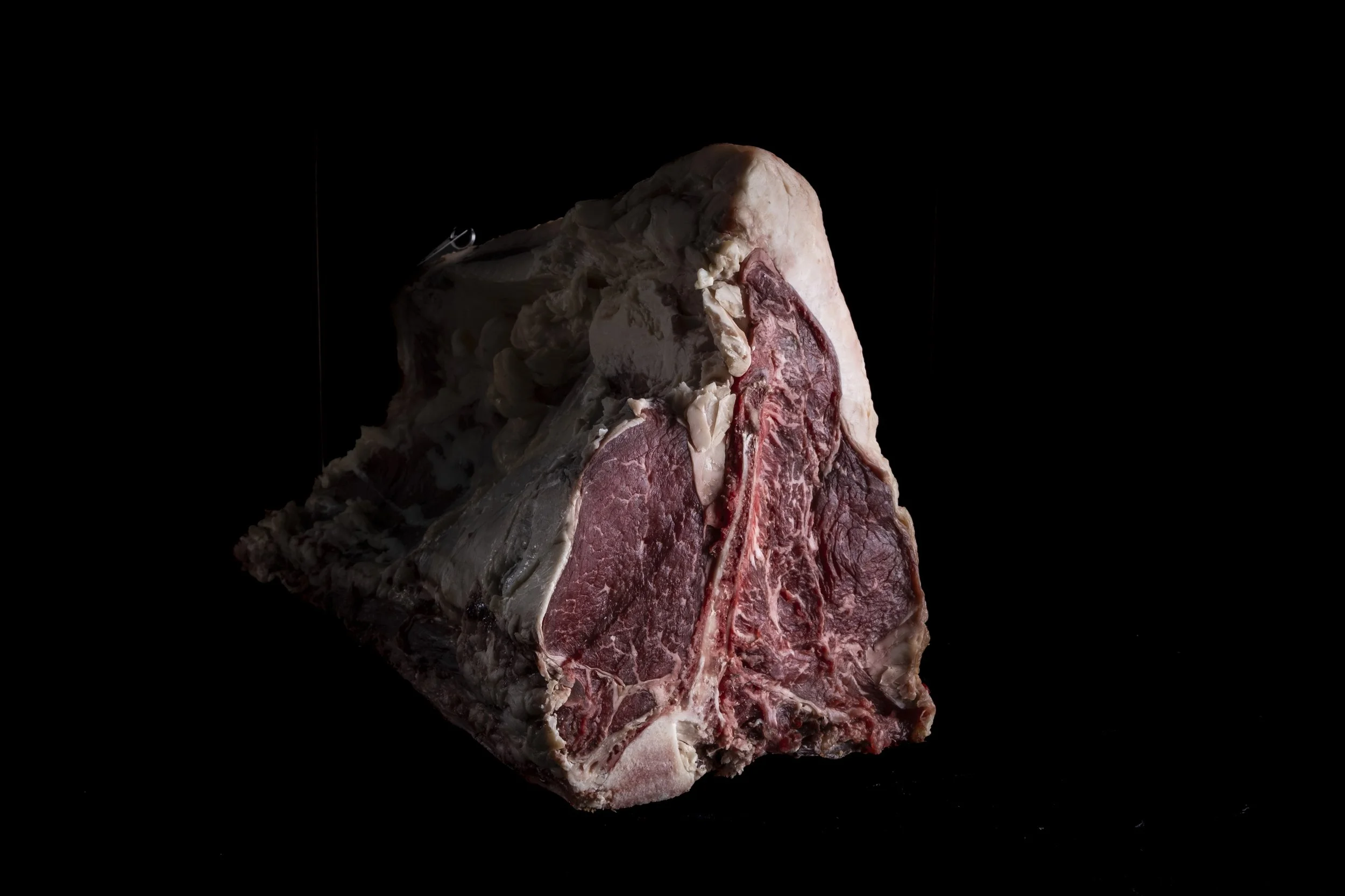 Taglio di carne cruda su sfondo nero.