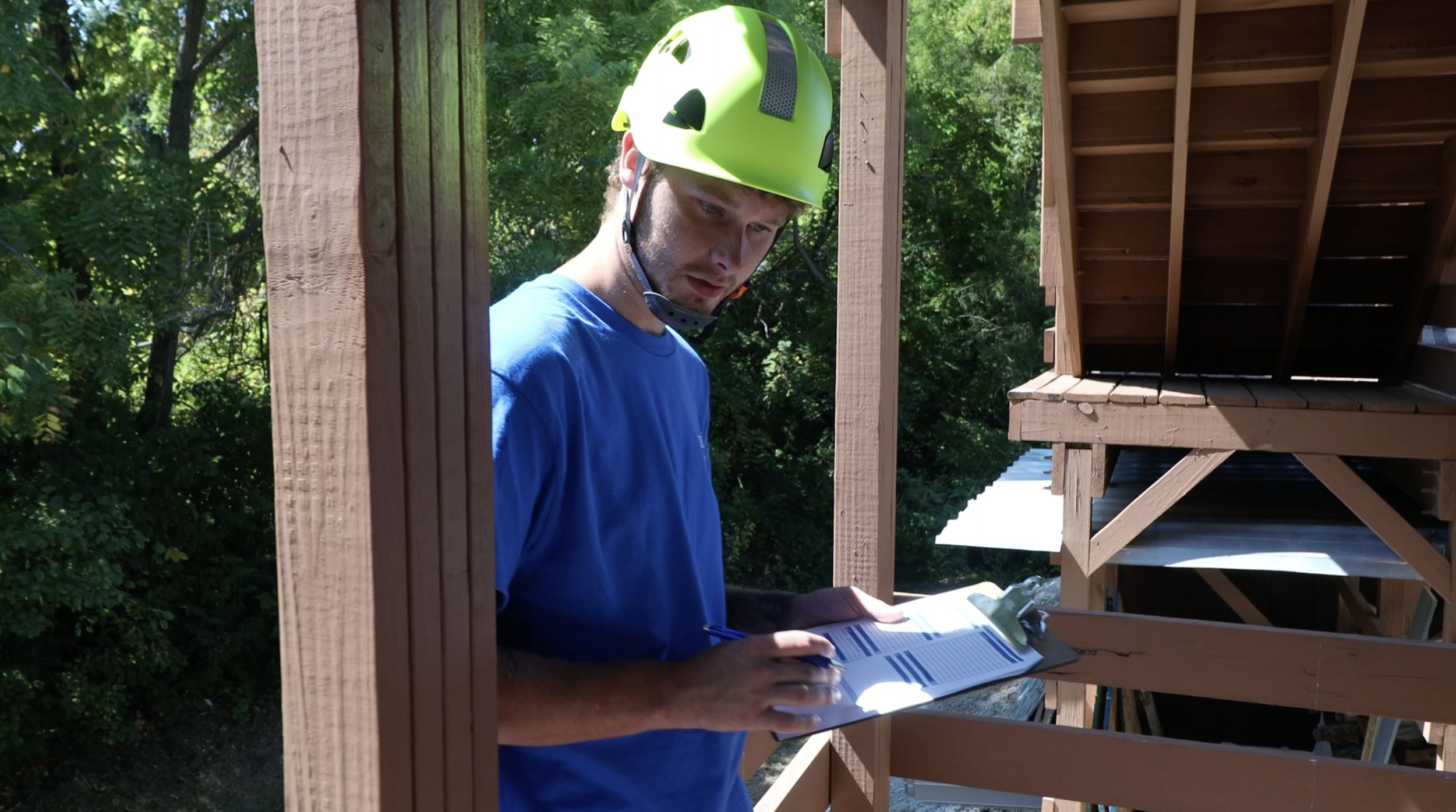 A student with a clipboard examining a mock chimney.