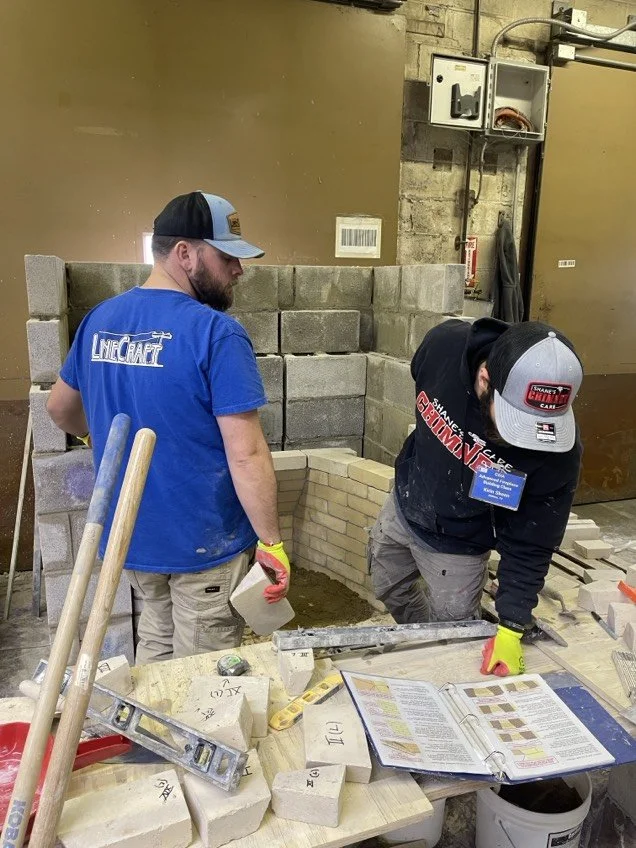 Two students looking over their worksheet while building masonry