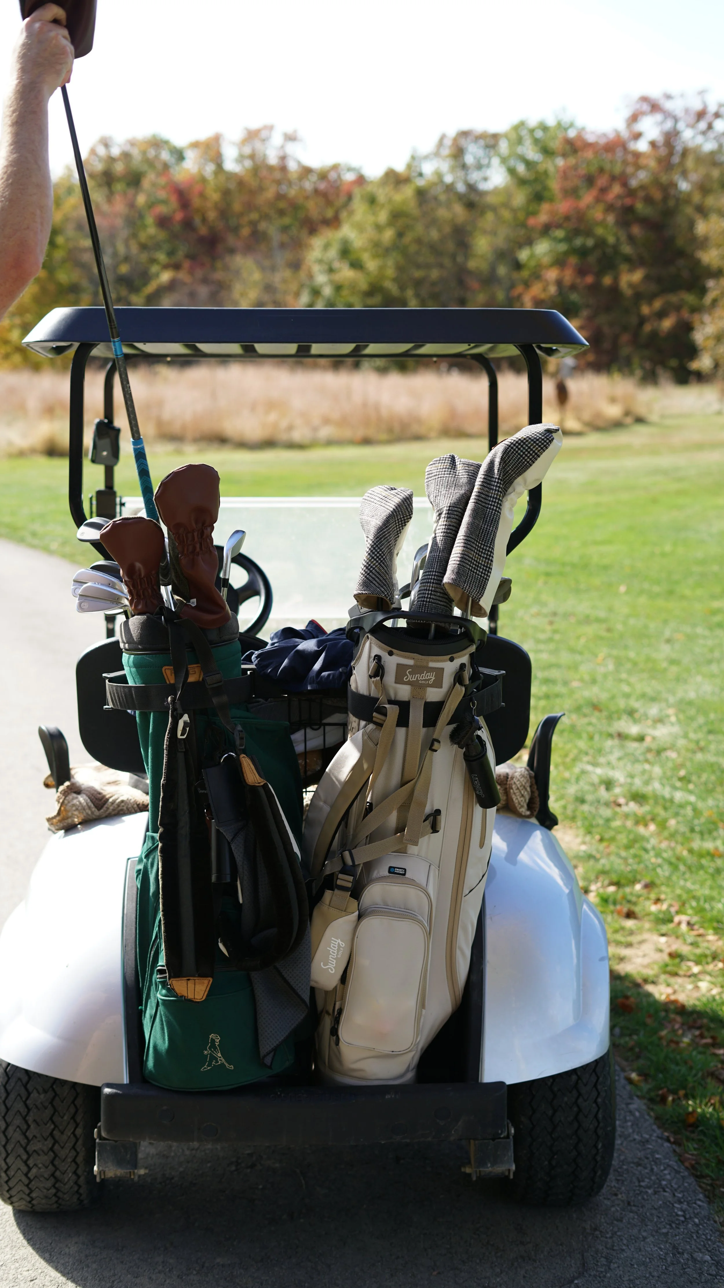 Two Golf Bags sit on the back of a golf cart with awesome Kells Golf Co Vintage Wool Headcovers