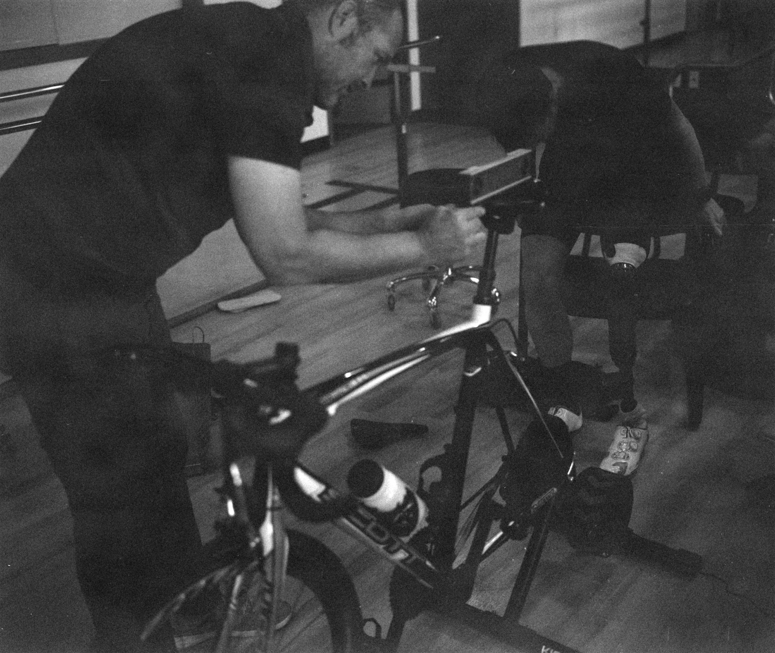 Mike adjusts takes measurements from Dave's bike while Dave adjusts his prosthesis