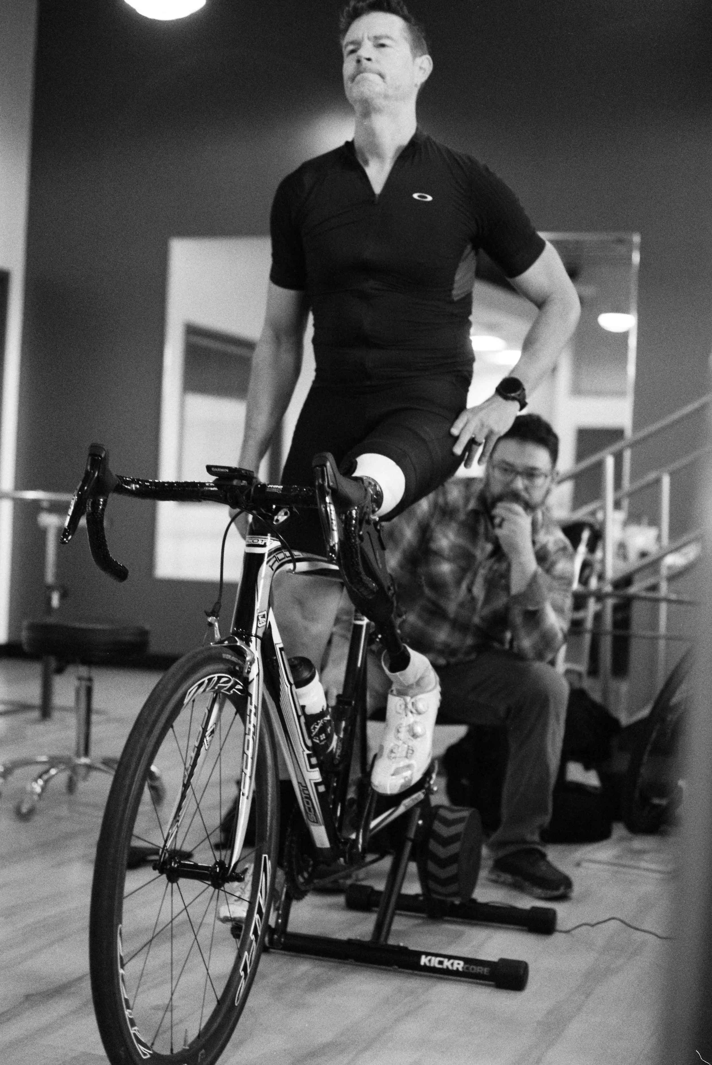 John inspects Dave's prosthesis with Dave on the trainer in John's office