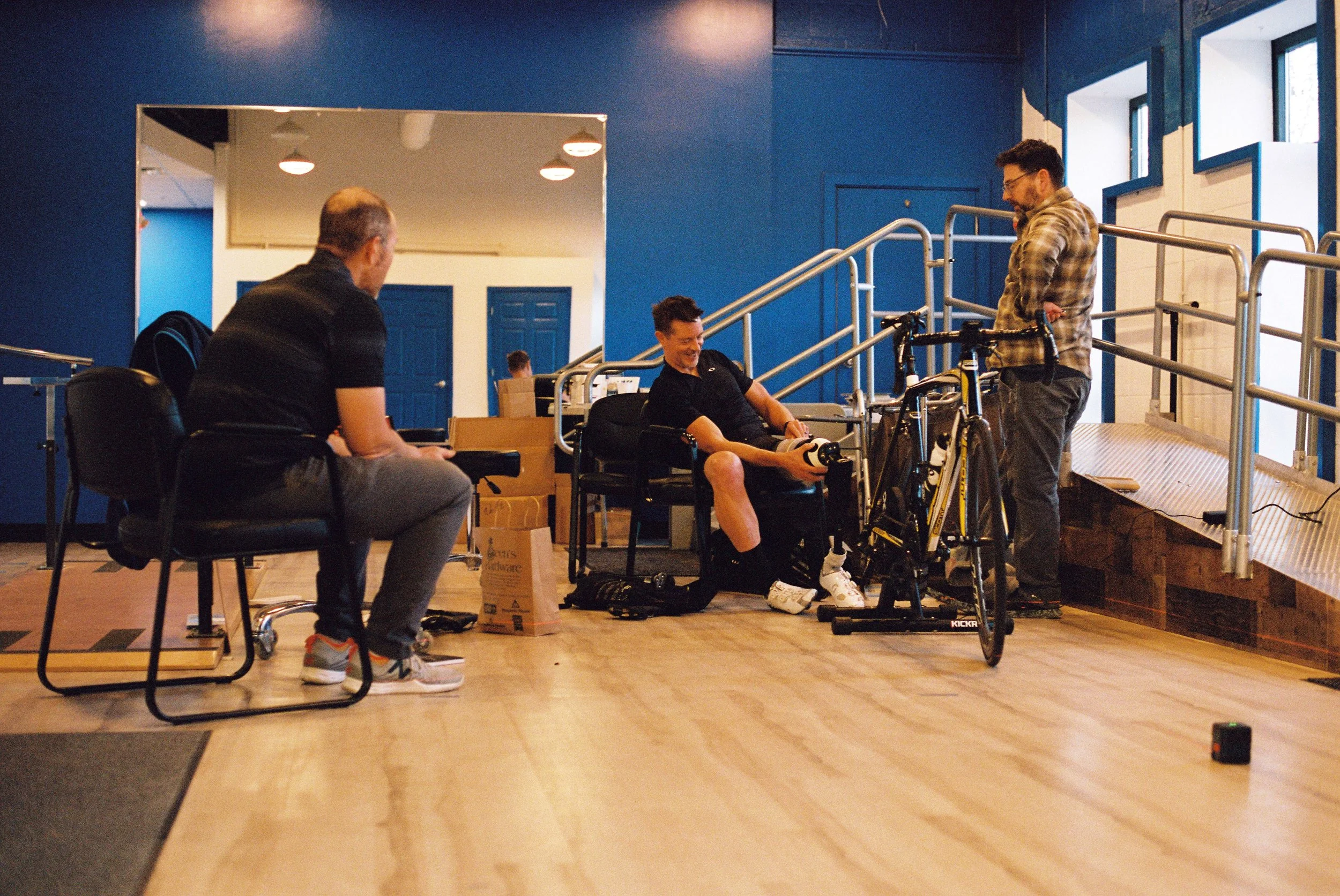 Dave adjusting his prosthesis with John and Mike in John's office