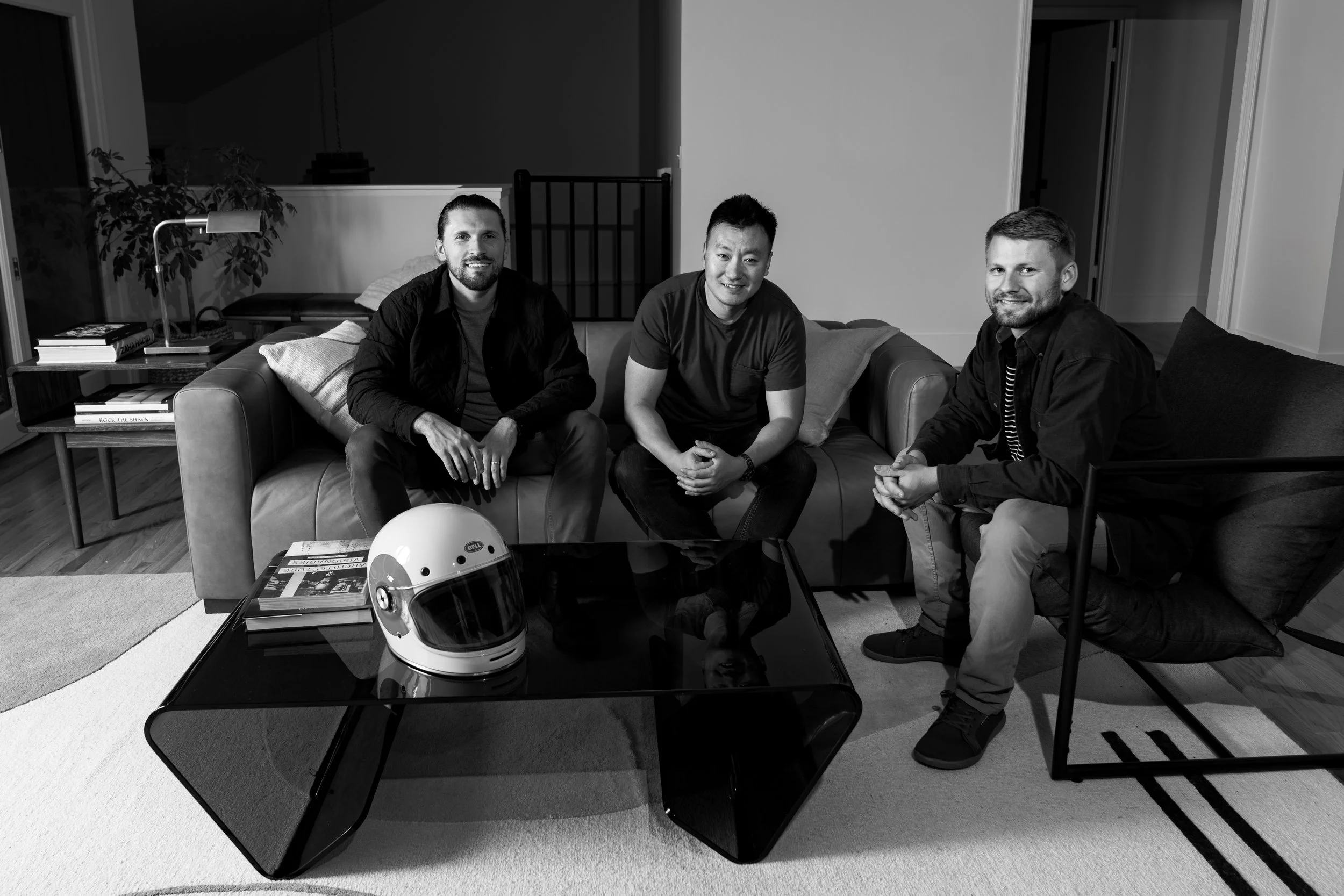 Trent Dingman, Michael Feng, and Nathan Melchers in the Real Motors office seated on a coach