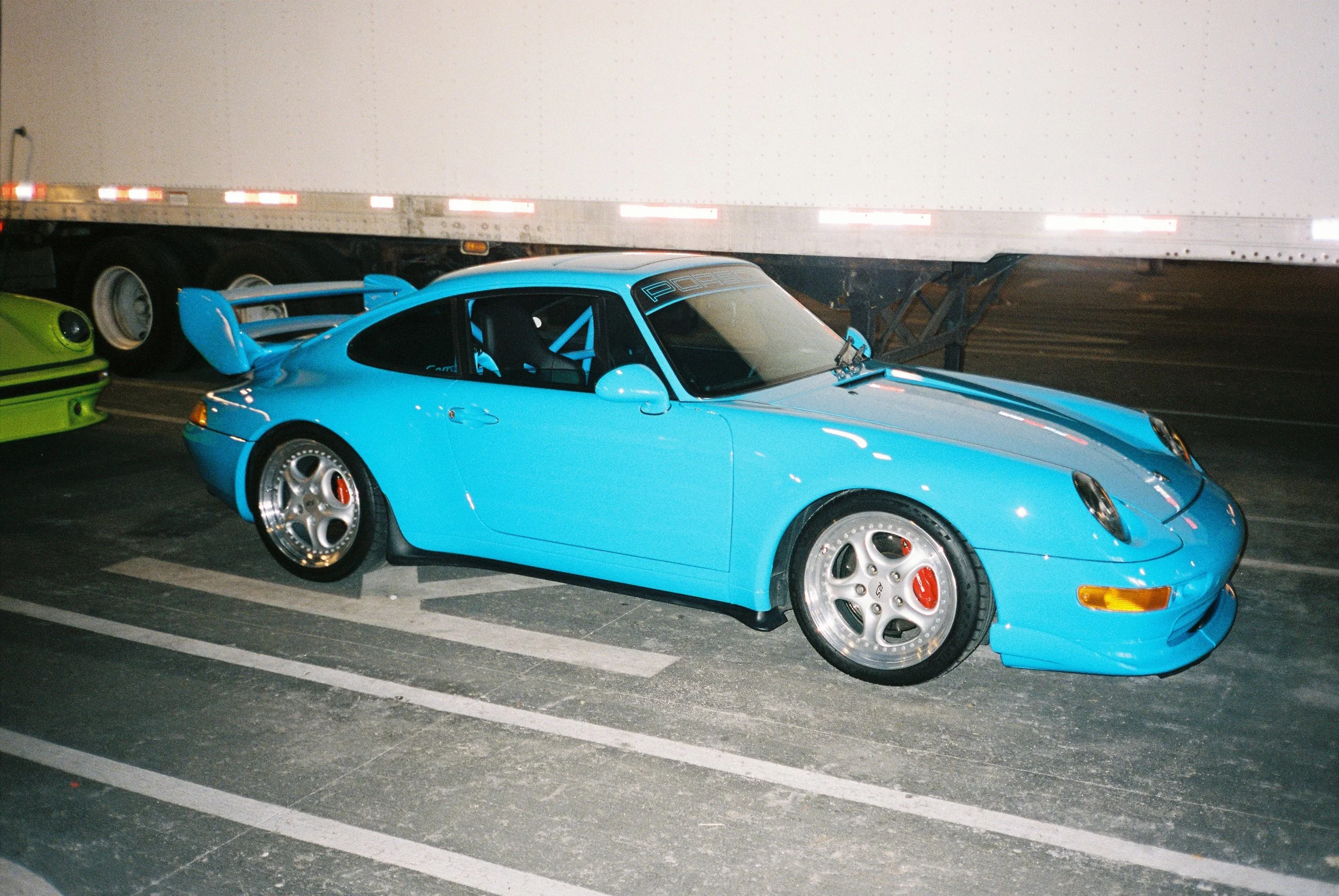 flash photography profile view of a bright blue custom Porsche 911