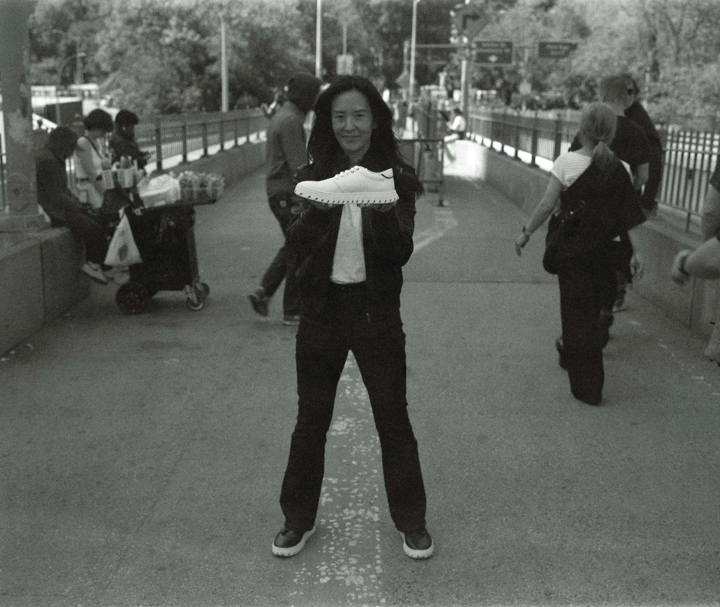 Maeve Wang in Brooklyn holding up a Model T IAMBIC shoe