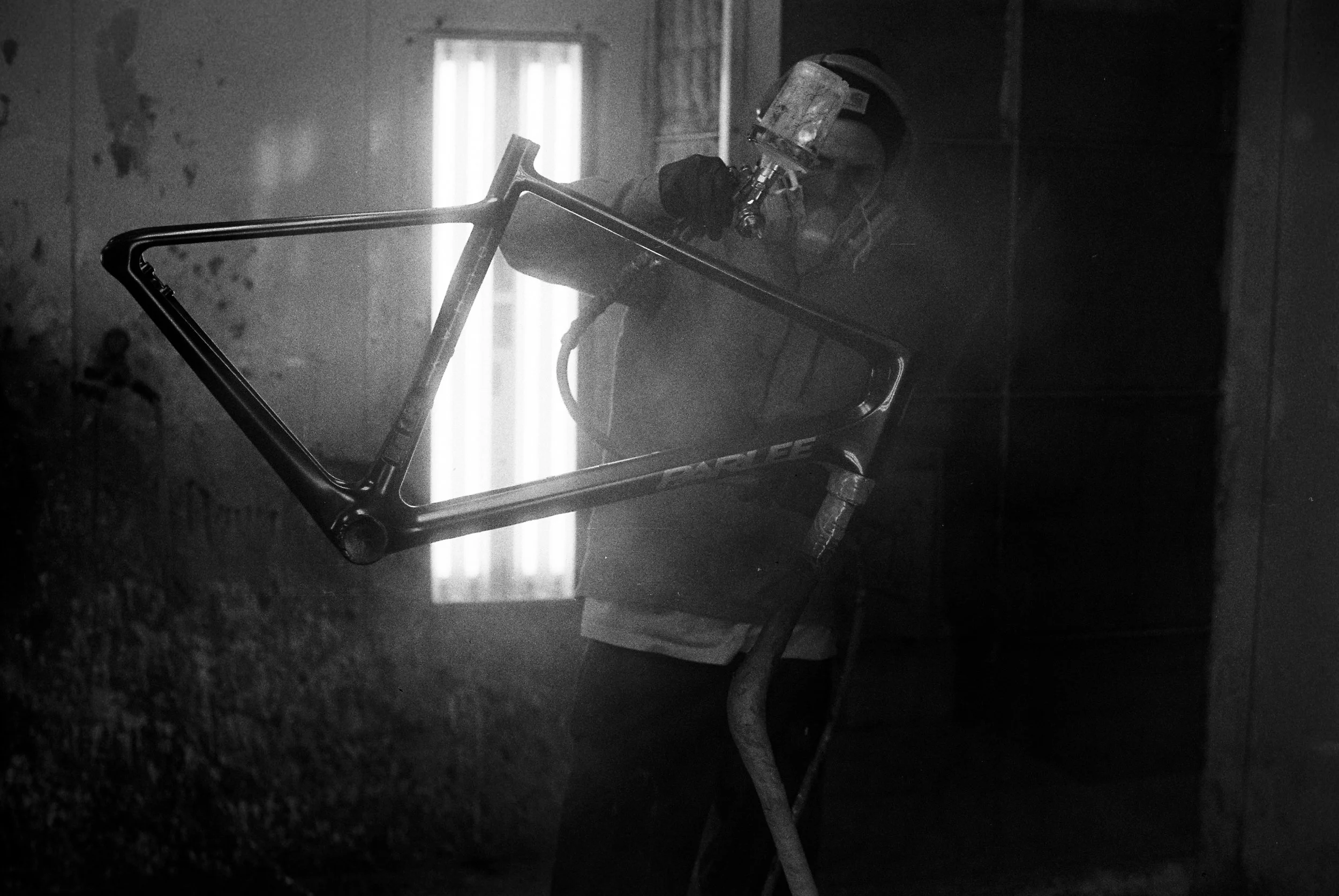Parlee's painter, applying a spray coat to a frame