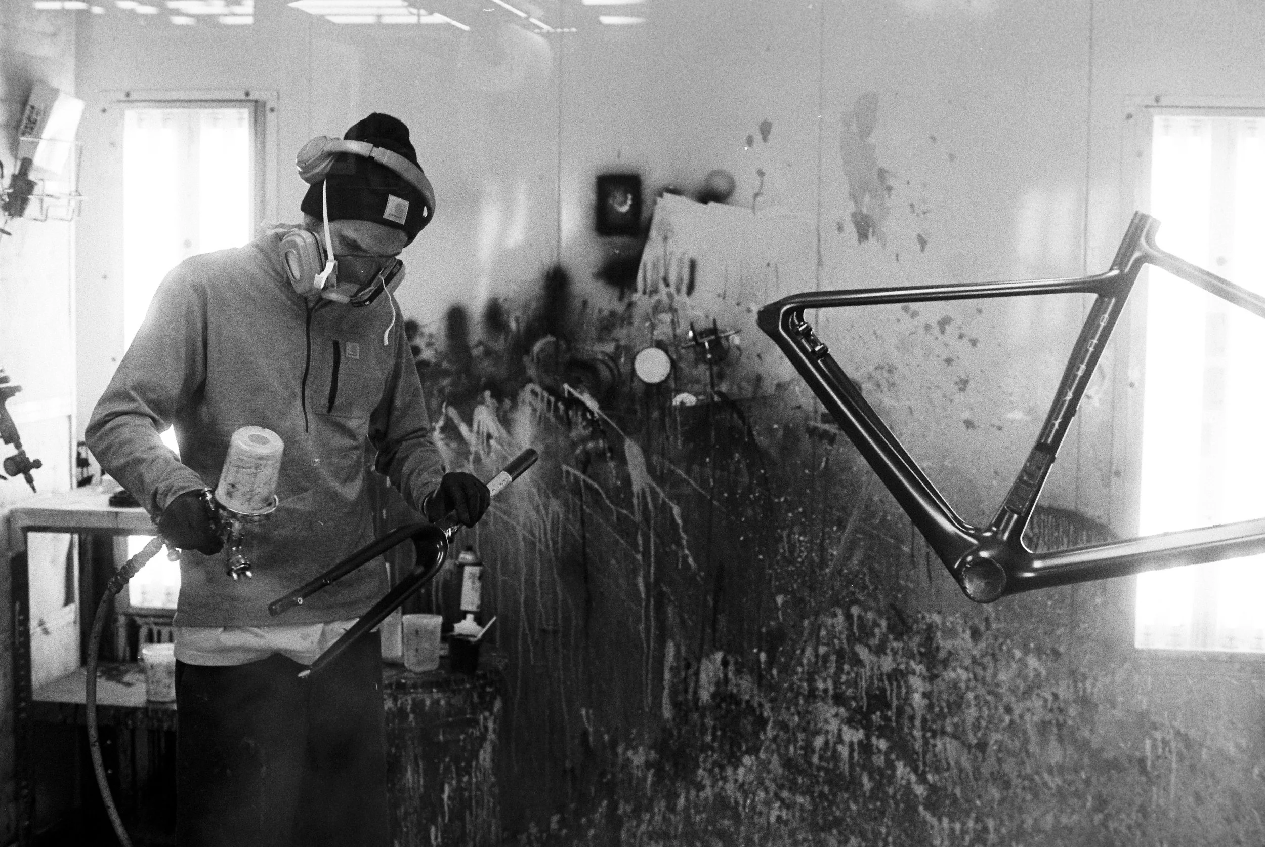 Cody Haight spray coats a Parlee frame in the paint room at Parlee headquarters
