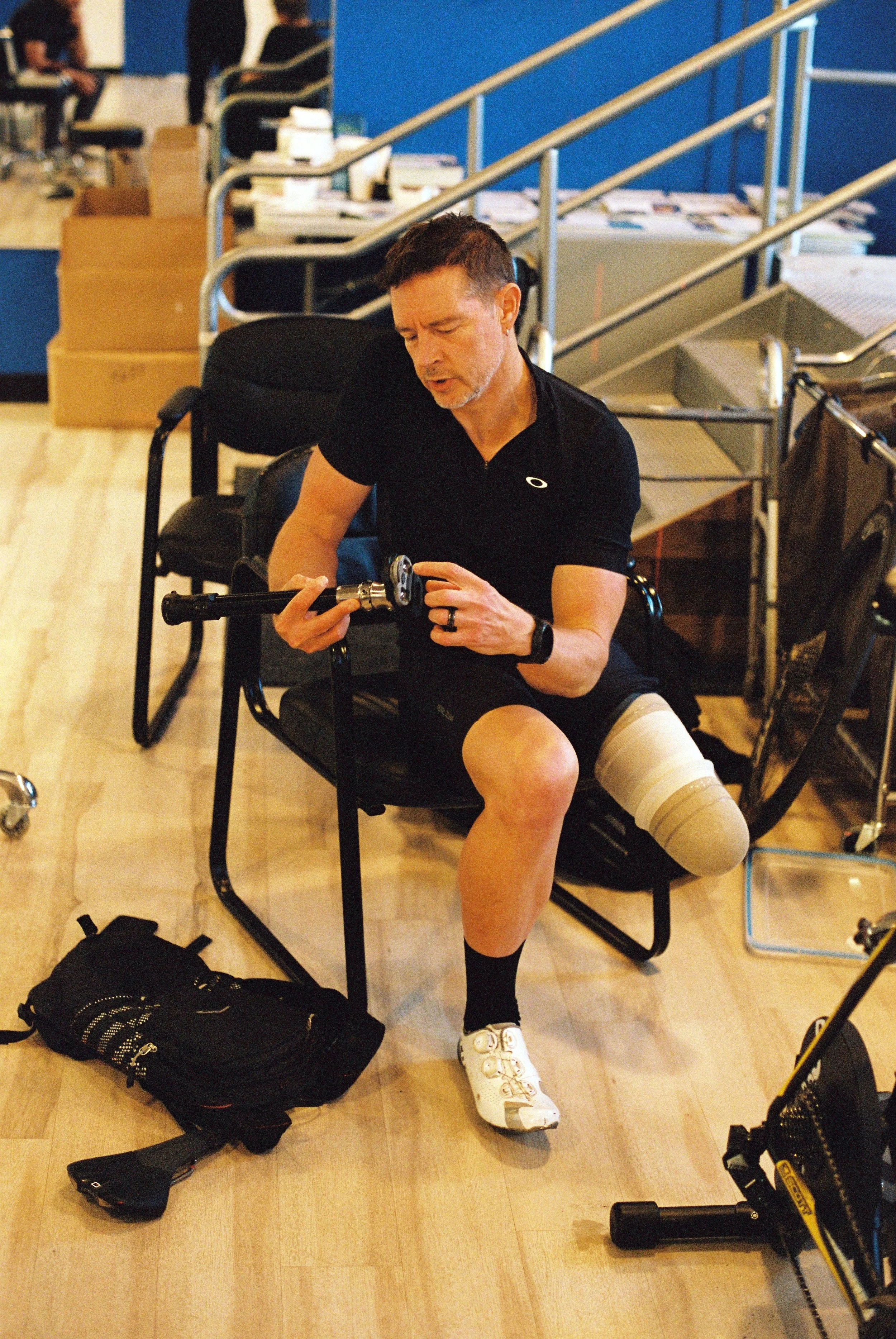 Dave holds his prosthesis to adjust its settings in John's office